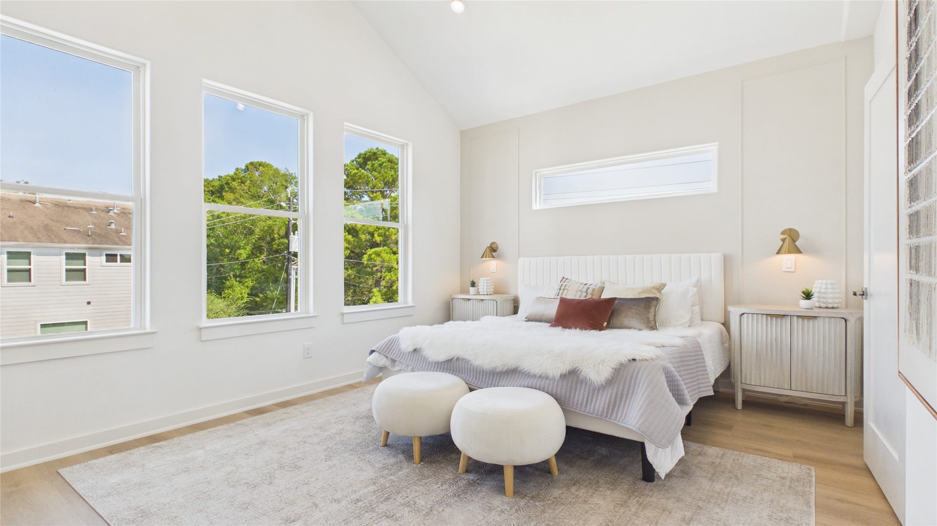 Primary bedroom featuring cathedral ceilings and complemented by a soft, neutral palette.
