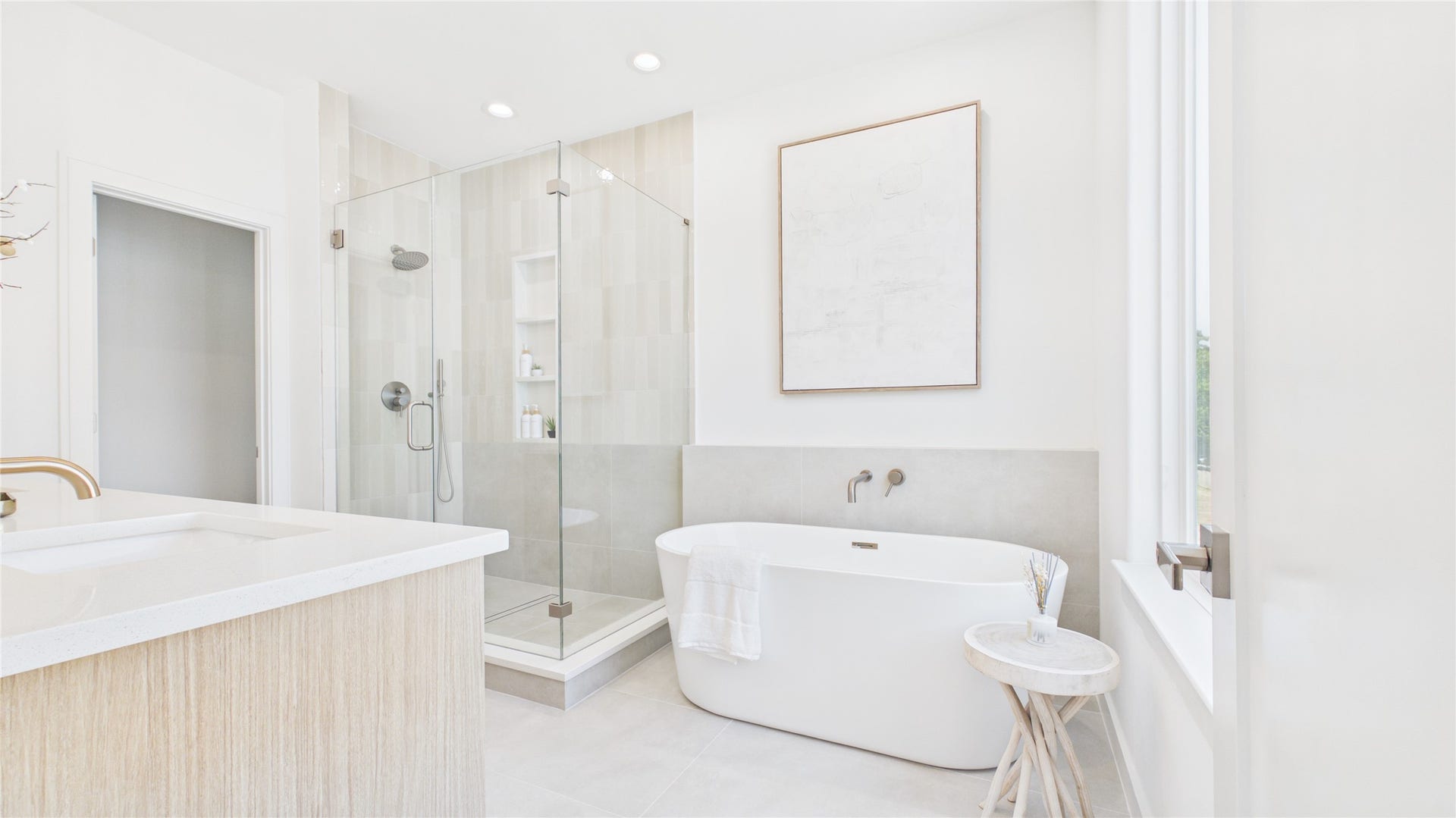 Experience luxury in this elegant bathroom featuring a spacious glass-enclosed shower and a sleek freestanding bathtub, complemented by modern fixtures and abundant natural light.