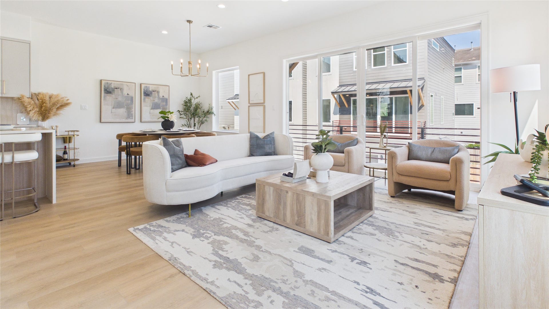 Open-concept living area featuring stylish hardwood floors, modern furnishings, and abundant natural light from large windows.