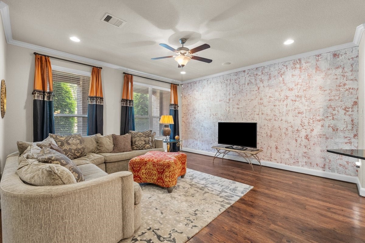 416 Via Regatta Drive, Webster, TX 77598 The bright and spacious family room features an abundance of natural light pouring in through large, double windows overlooking the front entryway