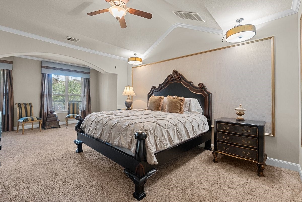 416 Via Regatta Drive, Webster, TX 77598 The expansive secondary-level primary retreat is a true sanctuary, featuring dramatic vaulted tray ceilings highlighted by thick crown molding and a central ceiling fan.
