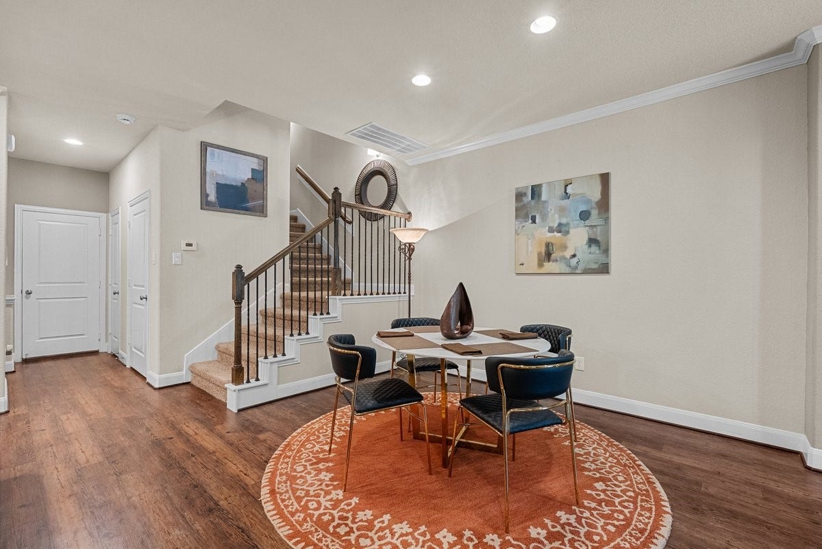 416 Via Regatta Drive, Webster, TX 77598 A striking wrought-iron staircase leads to the upper levels, emphasizing the home's open, airy architectural design.
