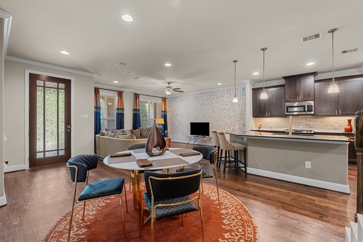 416 Via Regatta Drive, Webster, TX 77598 The gourmet kitchen is a chef's dream, featuring a massive wrap-around island breakfast bar, elegant dark wood cabinetry, stainless steel appliances, and stylish pendant lights.