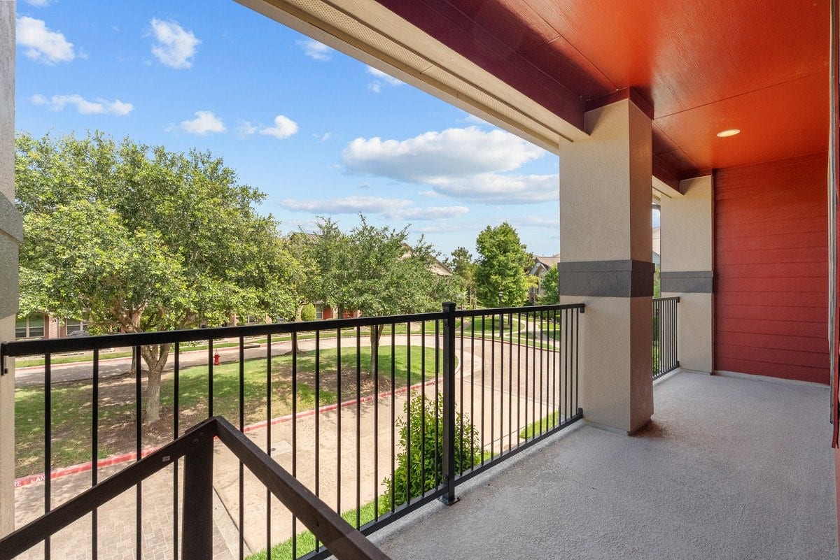 416 Via Regatta Drive, Webster, TX 77598 Step outside the primary suite onto your own massive, private second-floor covered balcony. This incredible outdoor living space features low-maintenance textured flooring, a rich painted ceiling with recessed lighting, and heavy-duty wrought-iron railing.Spanning a generous length, it offers the perfect peaceful spot for morning coffee or evening relaxation, all while enjoying elevated views of the beautiful, tree-lined cul-de-sac and neighborhood greenspace below.