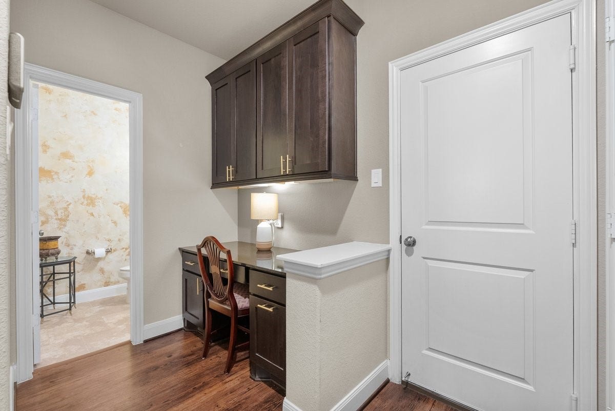 416 Via Regatta Drive, Webster, TX 77598 Tucked quietly away behind the kitchen, this highly functional space features a built-in study nook or butler's pantry, complete with sleek granite countertops, custom dark cabinetry, under-cabinet lighting, and built-in desk drawers.