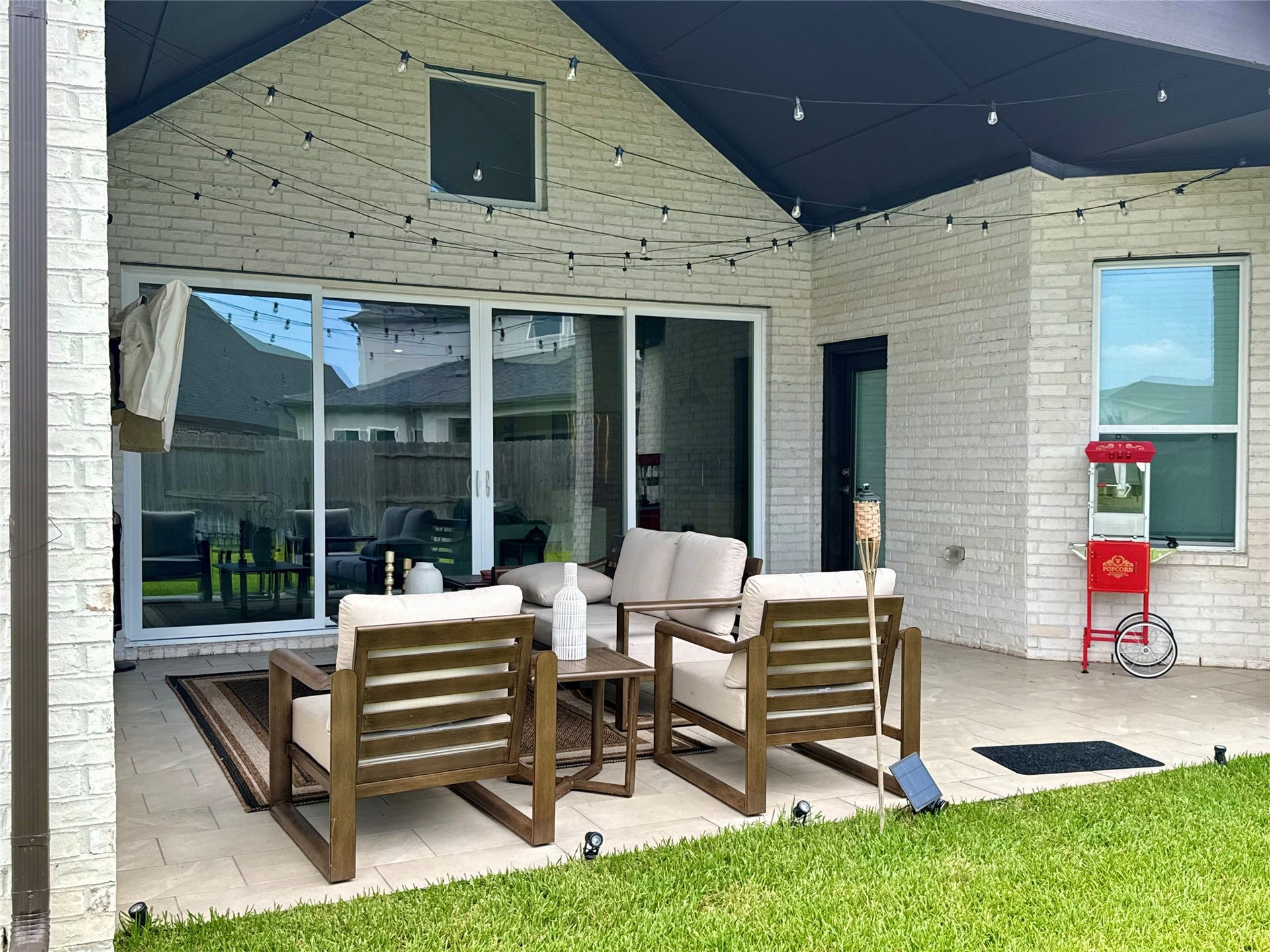 9911 Deep Water Drive, Missouri City, TX 77459 Charming covered patio with comfortable seating, furnished showing off string lights, perfect for outdoor entertaining.
