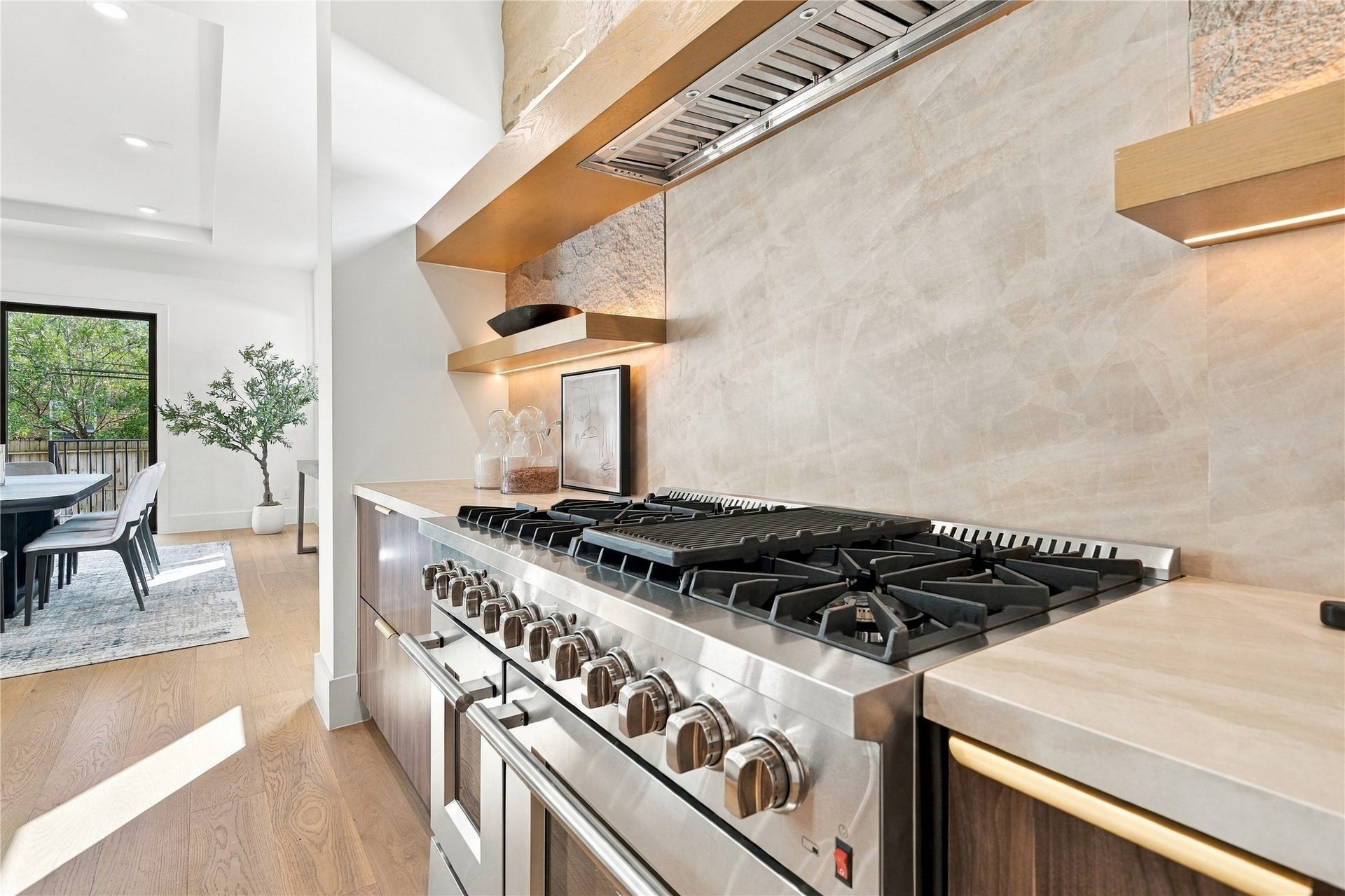 Professional-grade kitchen showcasing stainless steel appliances, custom cabinetry, and a stylish range hood.
