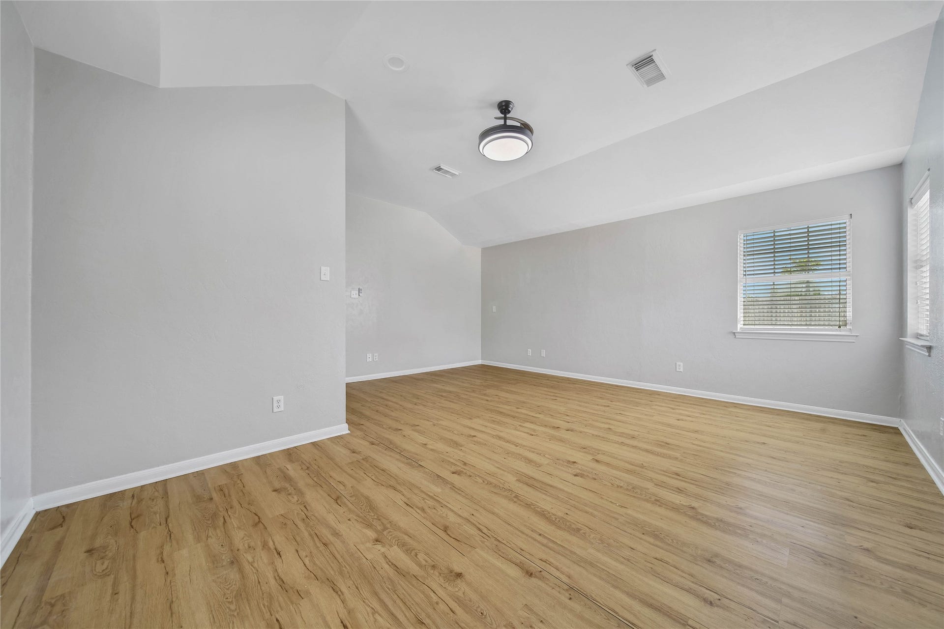 307 Lawrence Street, Tomball, TX 77375 A second view of the primary bedroom shows the vaulted ceiling with LED lighting and ceiling fan.