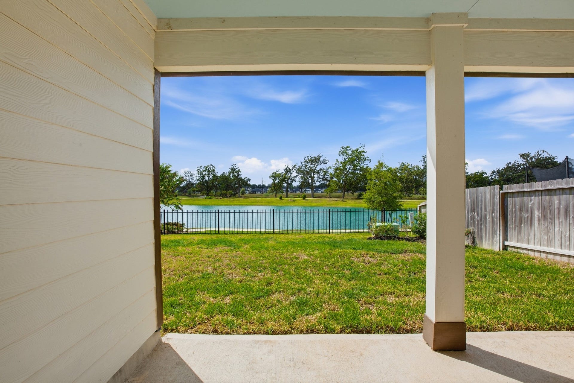 Enjoy serene water views from this covered patio, perfect for relaxation and outdoor gatherings.