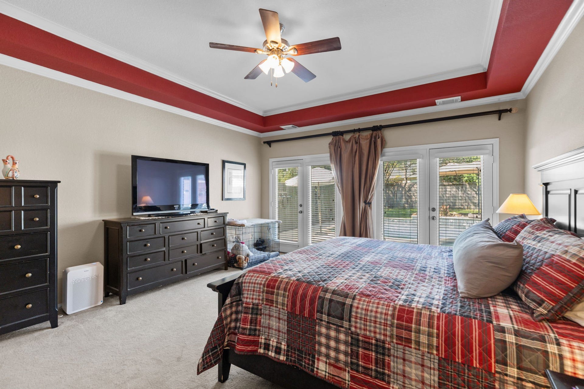 16319 Rolling View Trail, Cypress, TX 77433 Primary bedroom with trayed ceiling and double doors with a view of the pool. Lots of space in this huge primary!