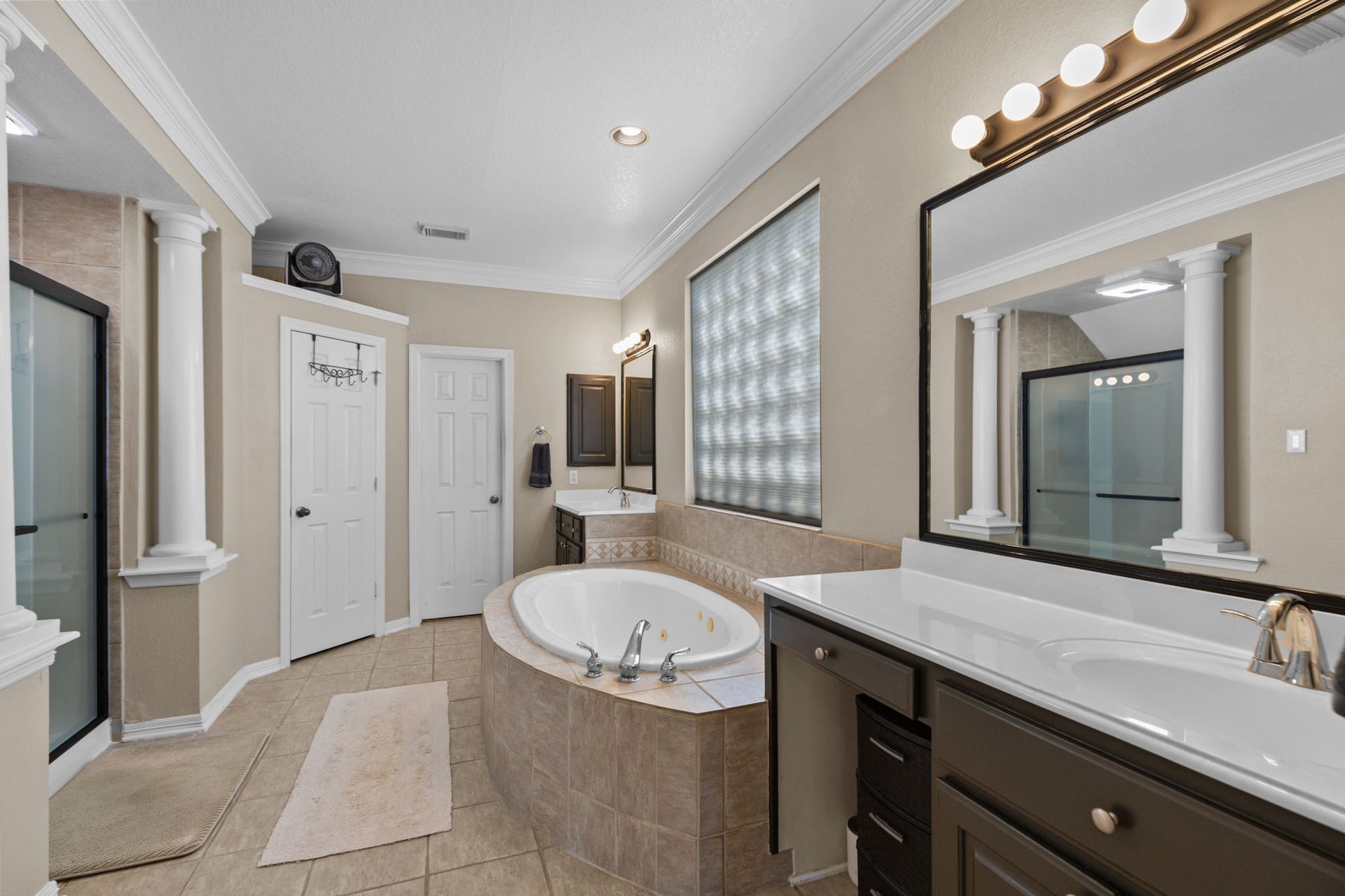 16319 Rolling View Trail, Cypress, TX 77433 The primary bath offers a whirlpool bath and brand new frosted glass shower door. His and her sinks with a vanity.