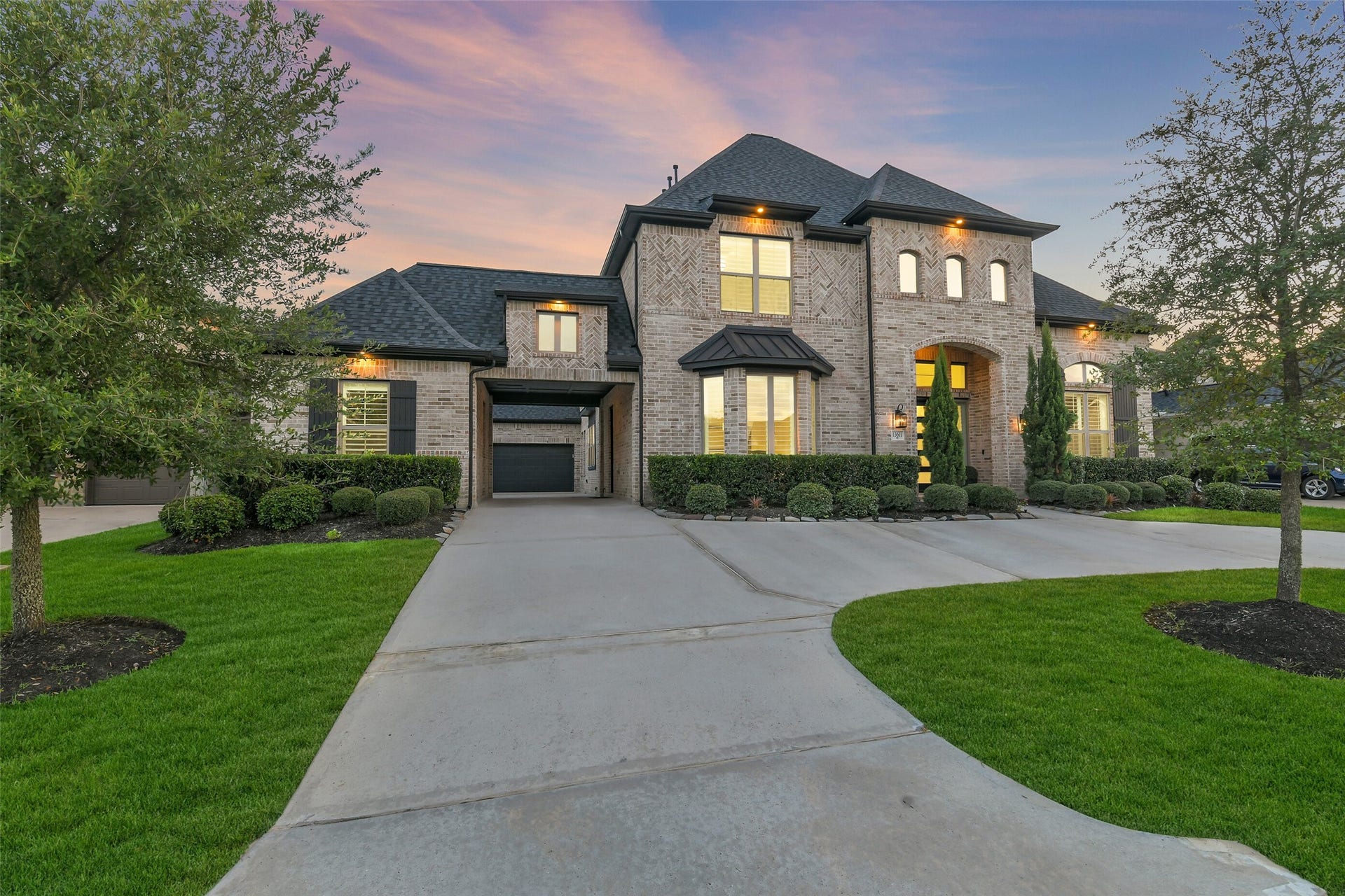 13611 Saddlebred Springs Lane, Cypress, TX 77429 Commanding brick exterior showcasing timeless architecture and exceptional curb appeal, enhanced by sophisticated under-eave accent lighting that beautifully illuminates the home after sunset. A grand porte-cochre creates an impressive arrival, while a roof less than two years old adds lasting value to this distinguished residence.