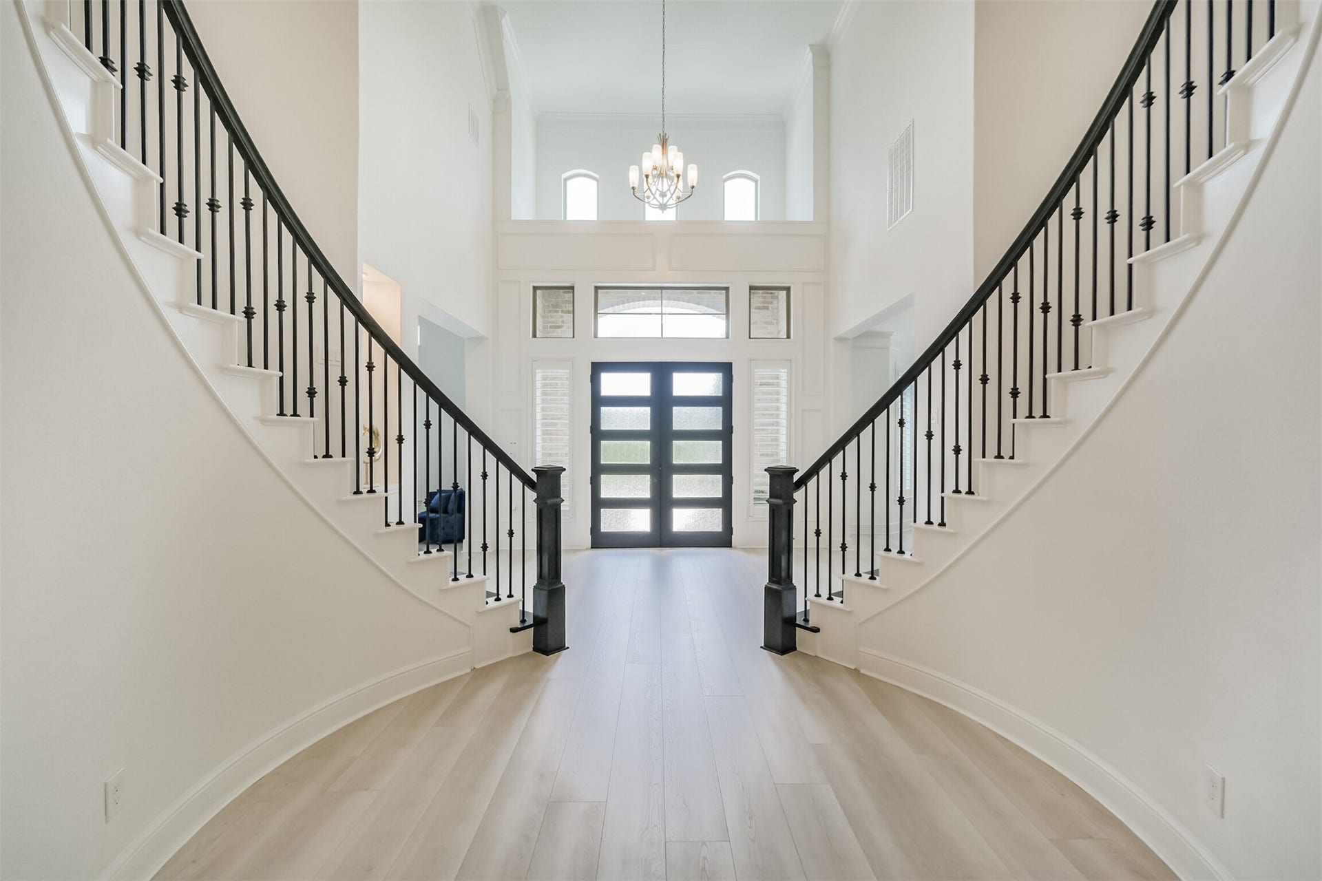 13611 Saddlebred Springs Lane, Cypress, TX 77429 Another view of the grand foyer, showcasing dramatic dual sweeping staircases, soaring ceilings, and rich engineered hardwood flooringcreating a refined and impressive entrance that sets the tone for the home.
