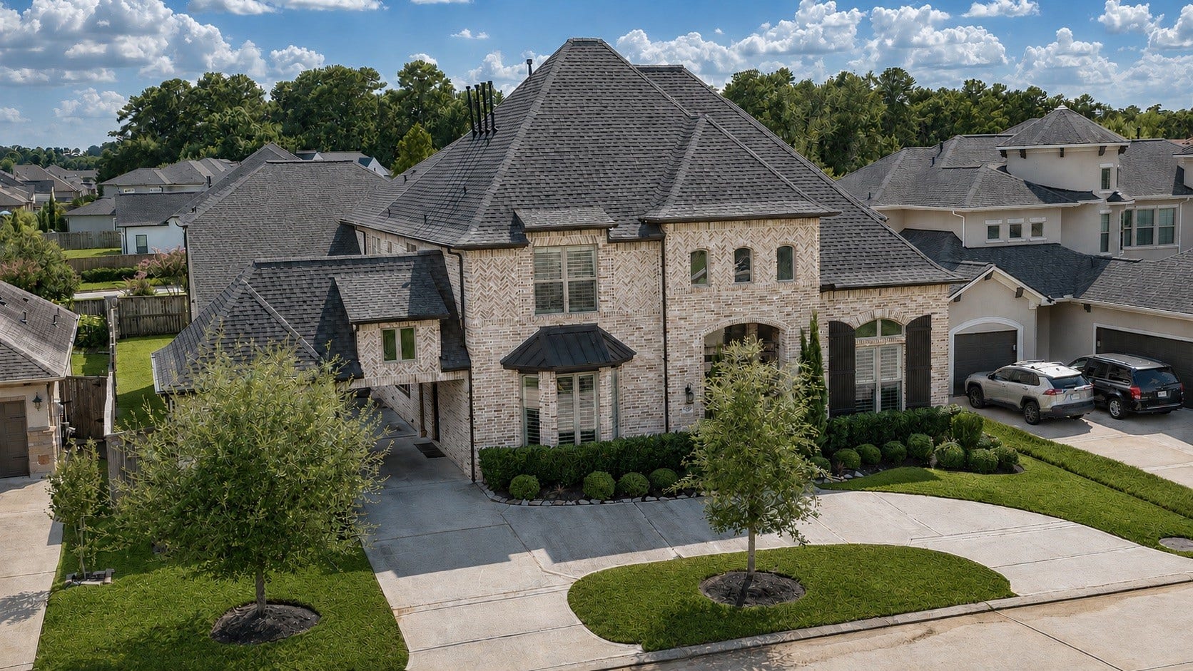 13611 Saddlebred Springs Lane, Cypress, TX 77429 Commanding aerial view of this distinguished brick residence, showcasing timeless architecture, intricate brickwork, a grand porte-cochre, and an expansive curved driveway. Manicured landscaping and impressive rooflines complete the homes exceptional curb appeal and elegant arrival.
