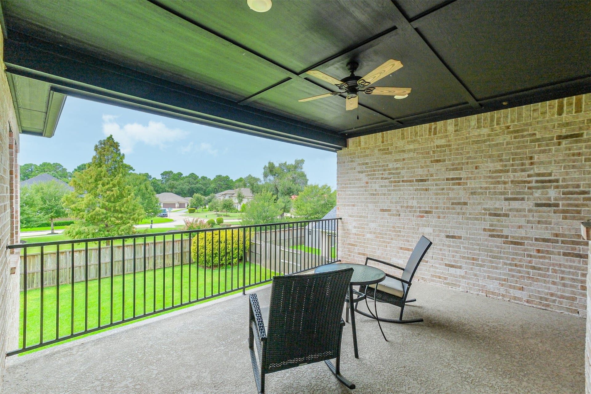 13611 Saddlebred Springs Lane, Cypress, TX 77429 Another view of the expansive second-floor covered balcony, featuring a ceiling fan and generous space for outdoor seating. Overlooking the lush backyard and surrounding neighborhood, this elevated retreat provides a serene setting for relaxing and enjoying the views.