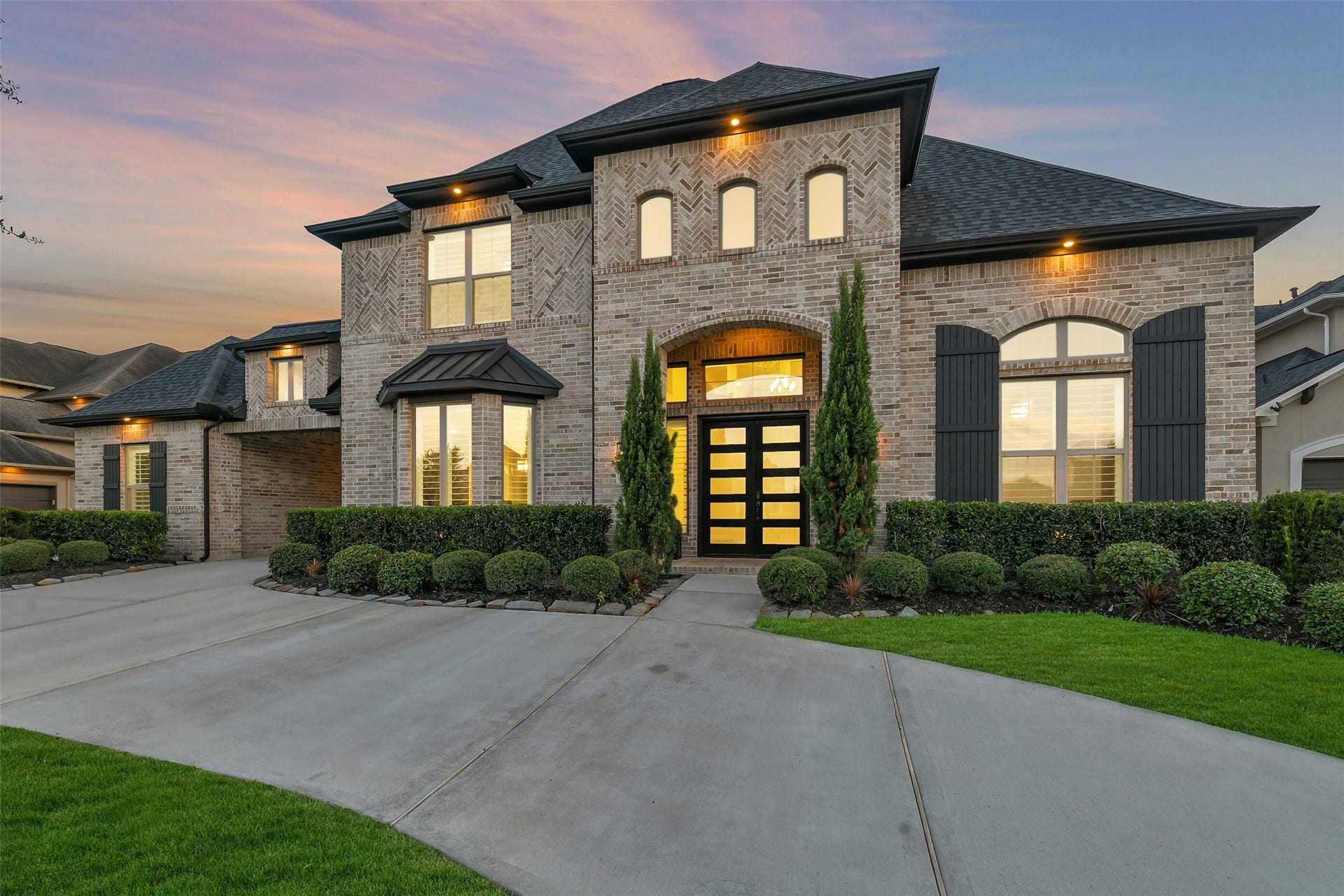 13611 Saddlebred Springs Lane, Cypress, TX 77429 Elegant two-story brick home featuring a spacious curved driveway, beautifully manicured landscaping, and striking black shutters. The roof is less than three years old, adding to the homes impressive curb appeal and value.