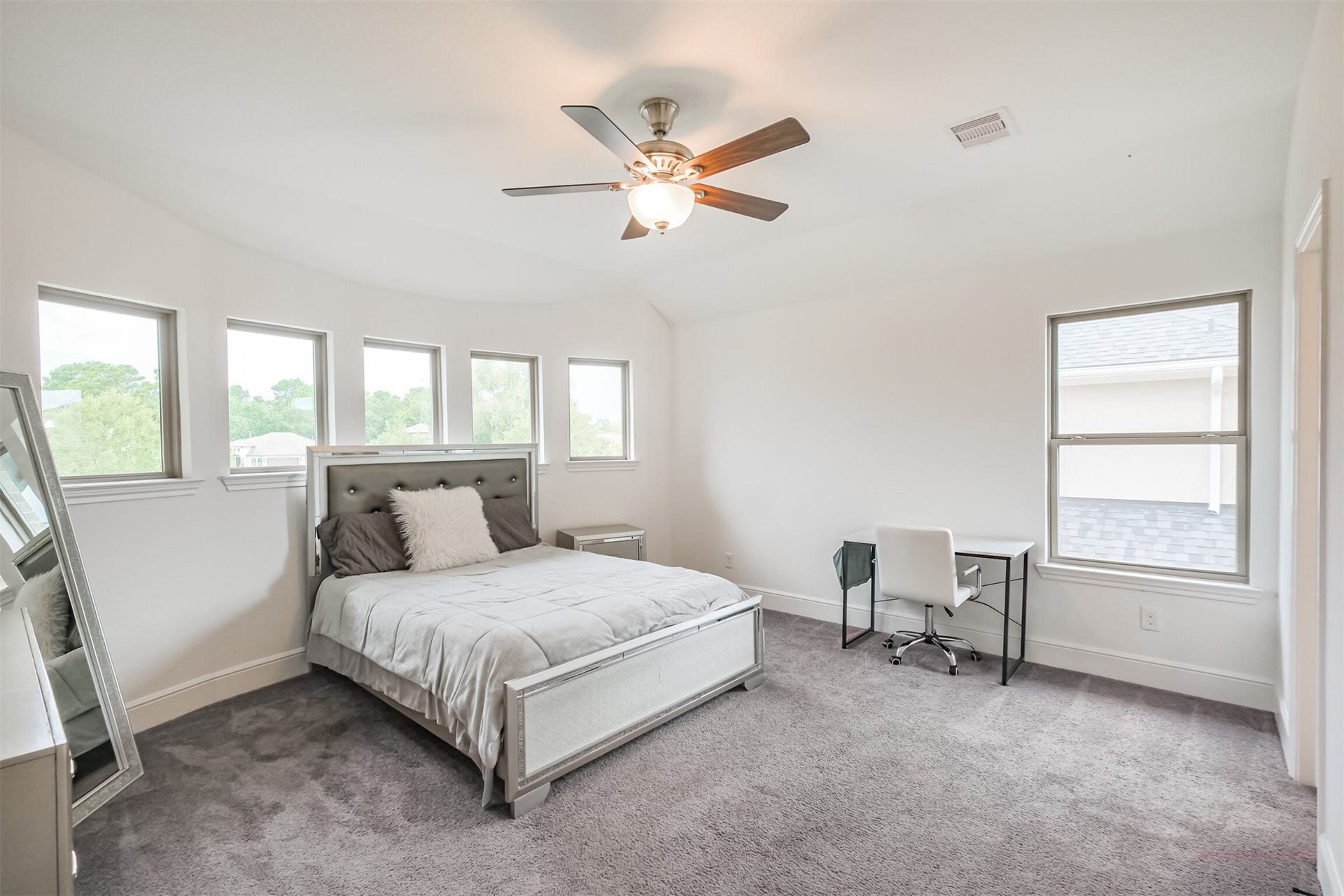 13611 Saddlebred Springs Lane, Cypress, TX 77429 Spacious second primary suite featuring multiple windows that fill the room with natural light, plush carpeting, and a ceiling fan for added comfort. A private en-suite bathroom completes this generously sized retreat, offering both privacy and convenience.