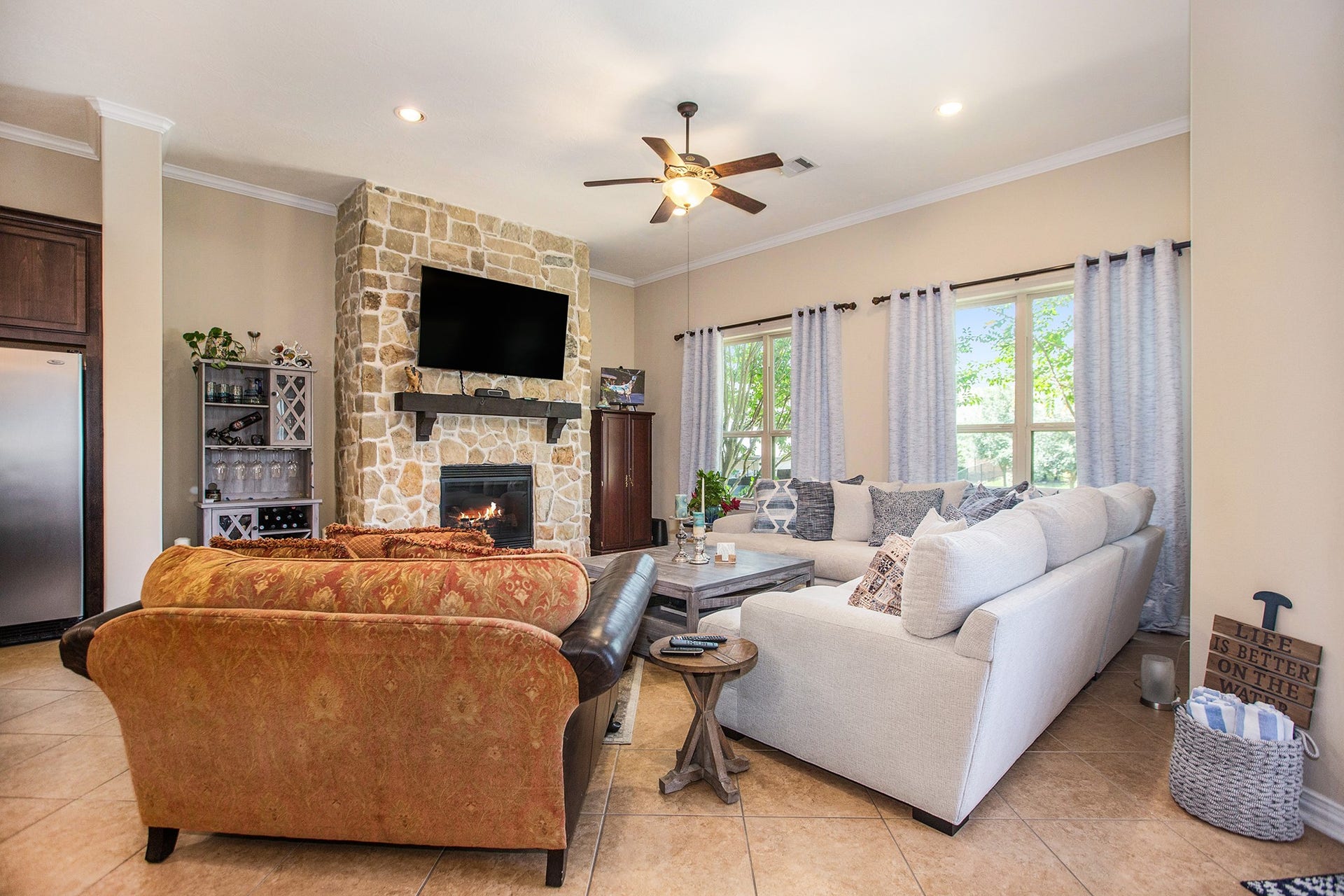 17931 Pecan Bayou Lane, Cypress, TX 77433 Family room boasts tile flooring, crown molding, ceiling fan and fireplace with stunning rock accent wall.