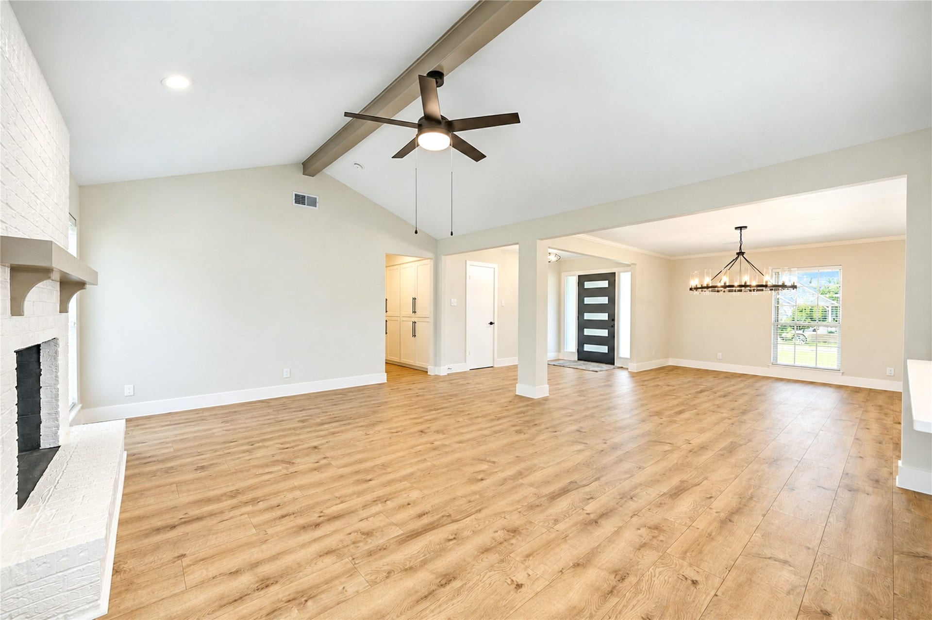 10607 Del Monte Drive, Houston, TX 77042 Another view of the spacious family room featuring a vaulted ceiling, decorative wood beam, contemporary ceiling fan, and new wide-plank engineered wood flooring.