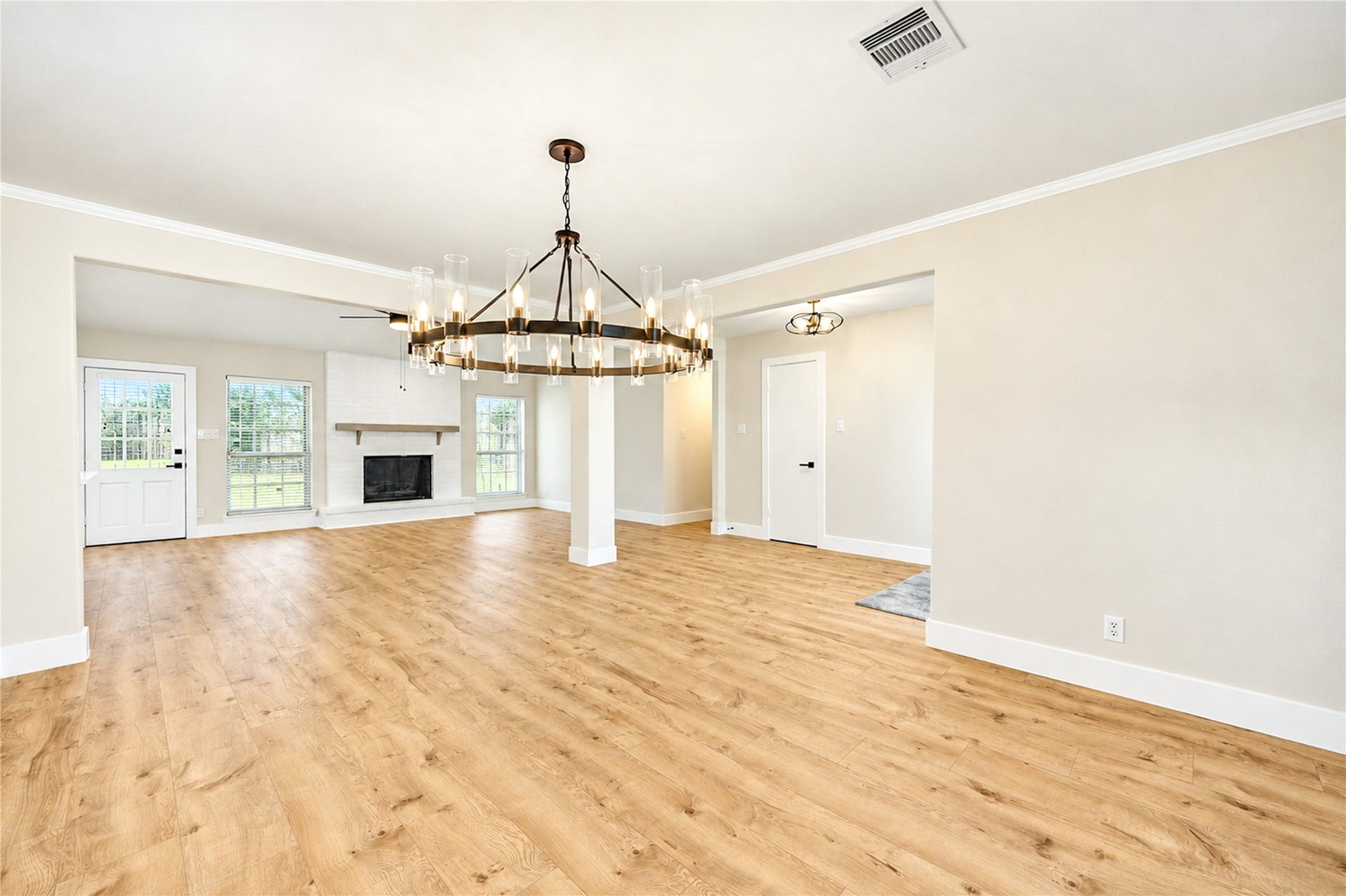 10607 Del Monte Drive, Houston, TX 77042 Expansive view highlights the open flow between the dining and family rooms, featuring new engineered wood flooring, contemporary ceiling fans, and updated lighting throughout.