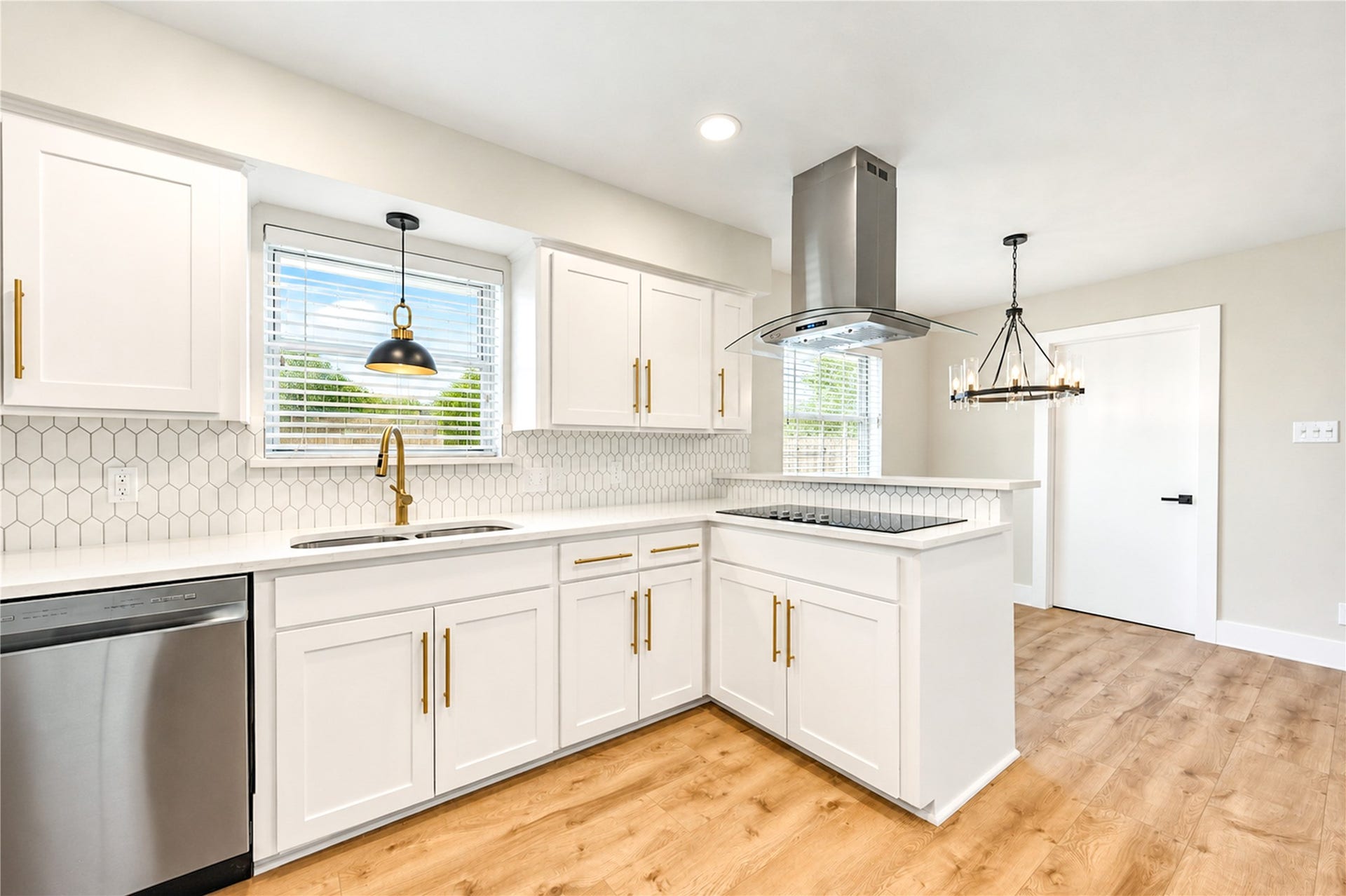 10607 Del Monte Drive, Houston, TX 77042 Bright kitchen features quartz countertops, designer backsplash, stainless steel appliances, and a convenient breakfast bar overlooking the adjoining living spaces.