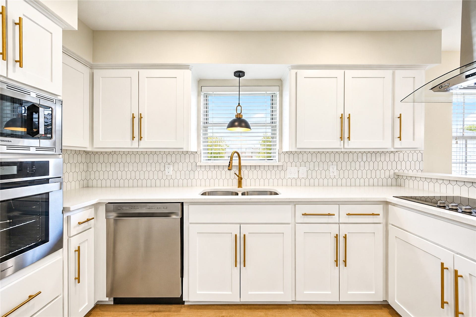 10607 Del Monte Drive, Houston, TX 77042 Beautifully remodeled kitchen showcases all-new stainless steel appliances, including built-in oven and microwave, elegant Shaker-style cabinetry with soft-close doors, gold hardware, and a designer tile backsplash.
