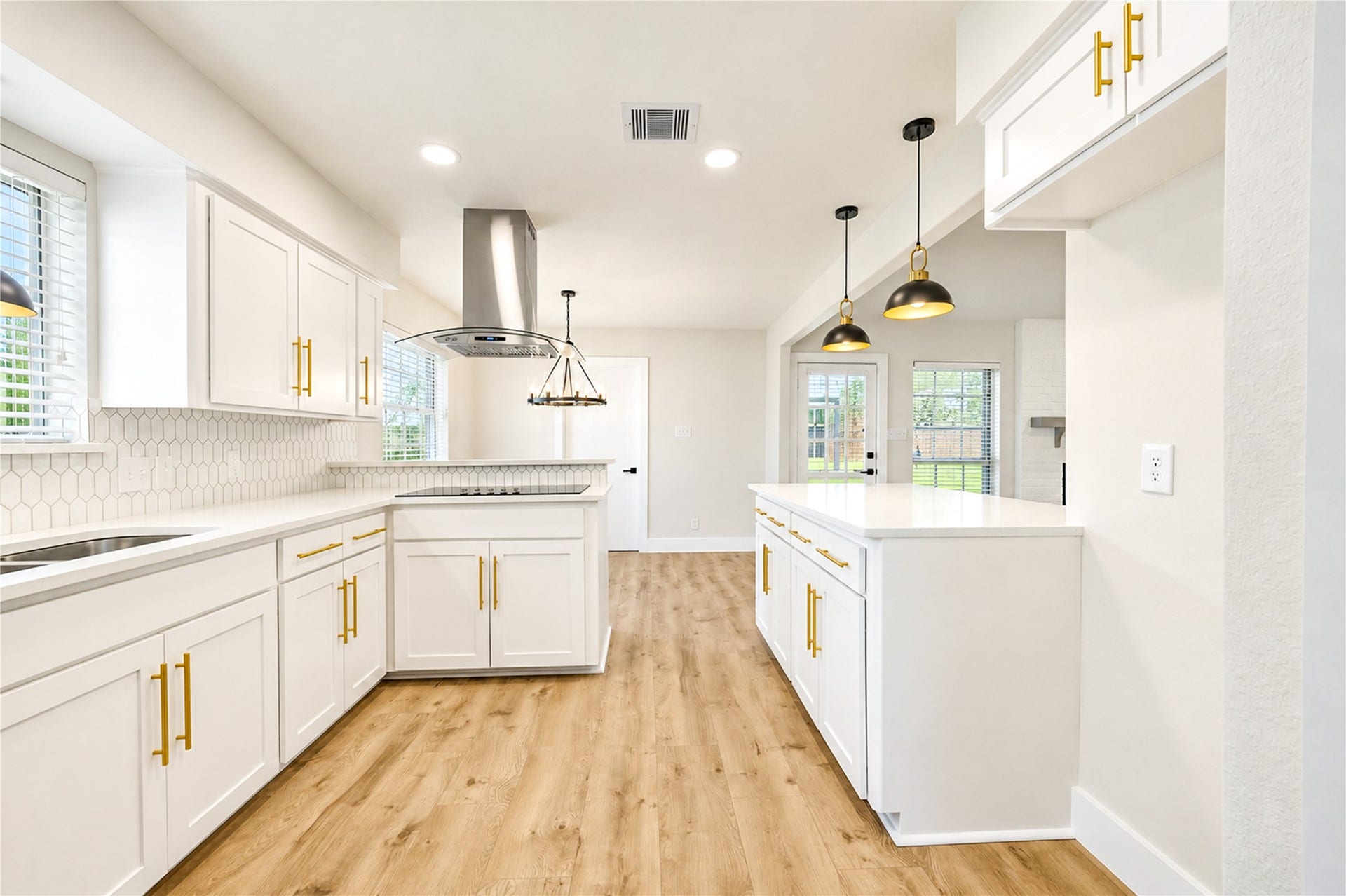 10607 Del Monte Drive, Houston, TX 77042 Another view of the beautifully remodeled kitchen highlights its functional layout, abundant shaker-style cabinetry, recessed lighting, and new wide-plank engineered wood flooring.