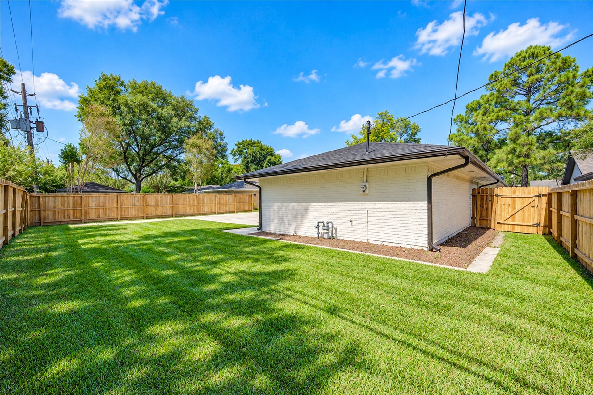 10607 Del Monte Drive, Houston, TX 77042 Beautiful backyard offers lush green lawn, privacy fencing, and ample space for a future swimming pool, playground equipment, or outdoor entertaining area.