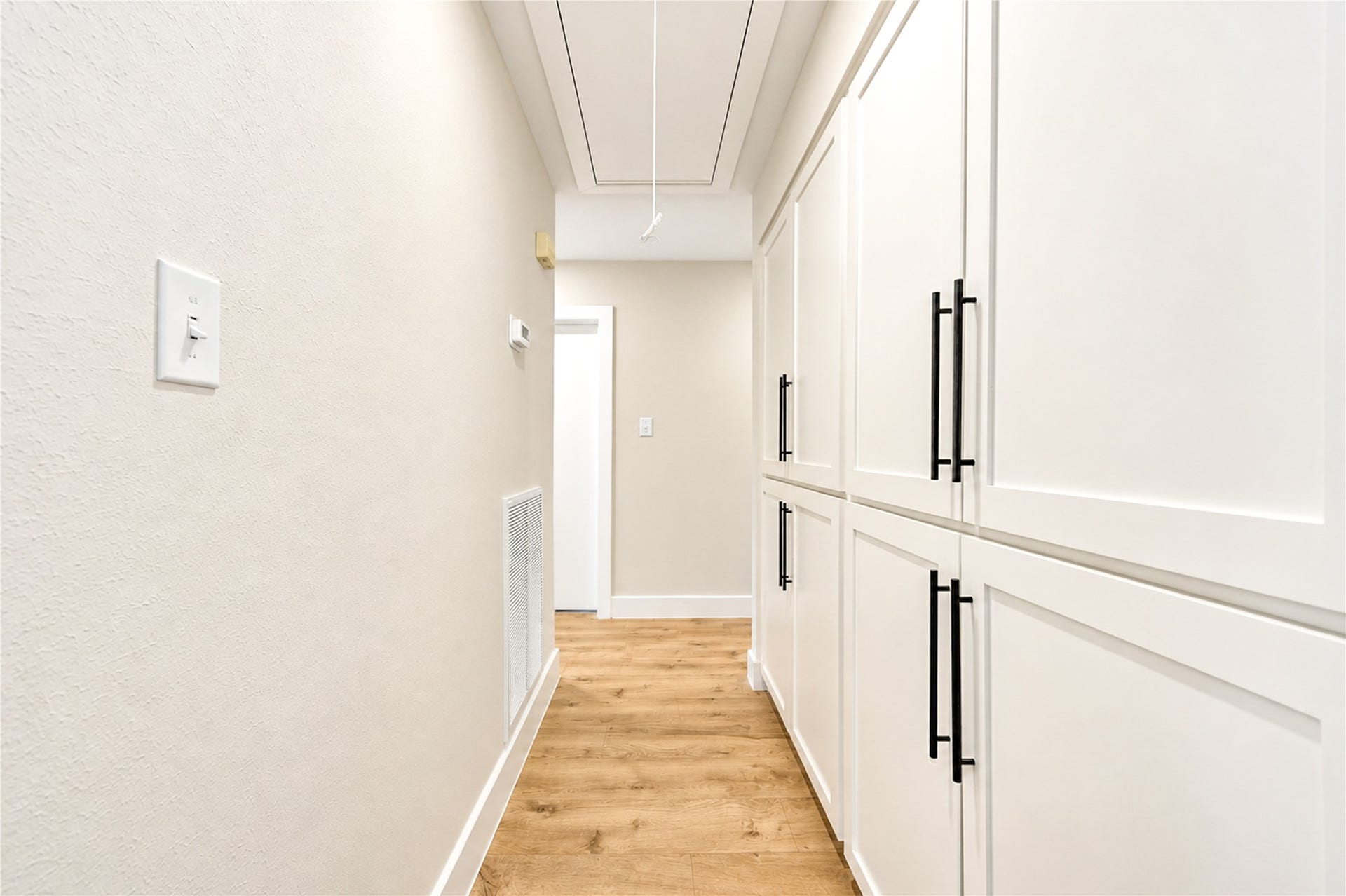 10607 Del Monte Drive, Houston, TX 77042 Impressive hallway features an entire wall of built-in storage cabinetry with all-new Shaker-style door fronts, providing exceptional storage and organization throughout the home.