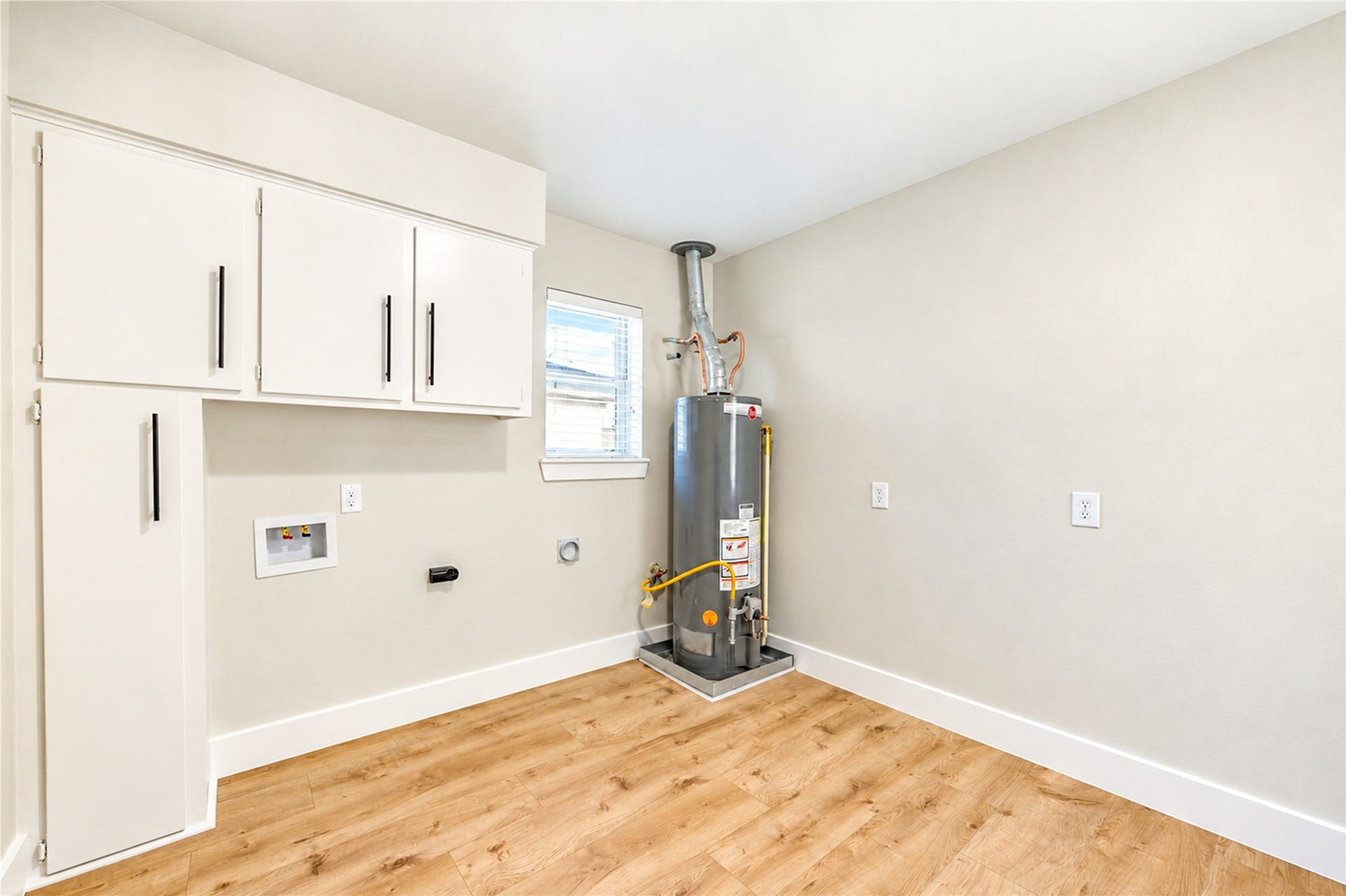 10607 Del Monte Drive, Houston, TX 77042 Spacious 10x10 laundry room features abundant cabinetry and storage along BOTH walls, new wide-plank engineered wood flooring, and a convenient exterior door providing direct access to the covered patio!