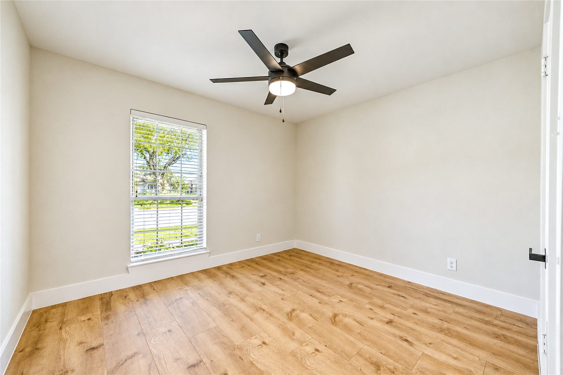 10607 Del Monte Drive, Houston, TX 77042 Bright and inviting secondary bedroom features new wide-plank engineered wood flooring, a contemporary ceiling fan, fresh neutral finishes, and abundant natural light.