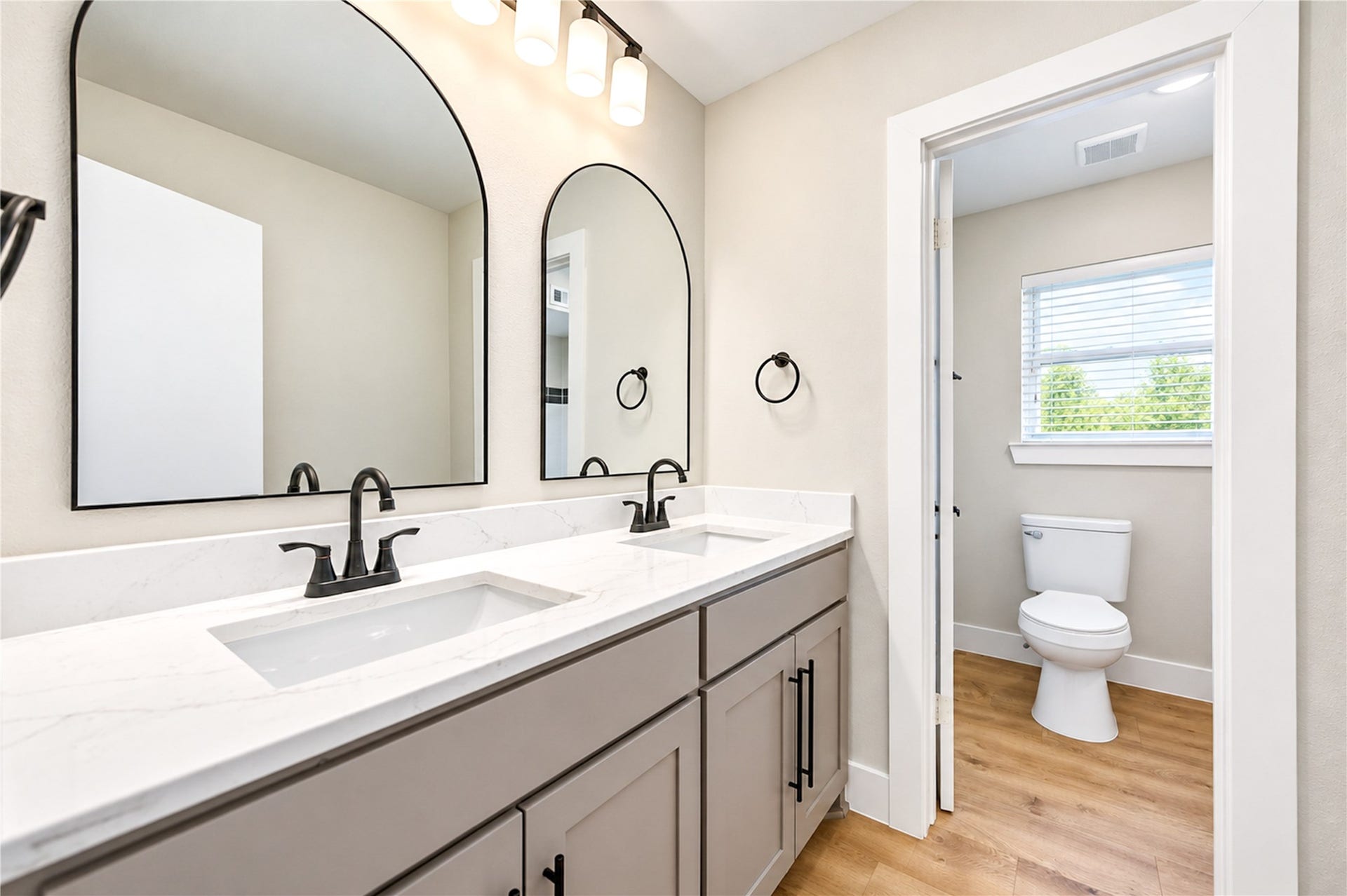 10607 Del Monte Drive, Houston, TX 77042 Beautifully remodeled secondary bathroom features a spacious dual-sink vanity with all-new Shaker-style cabinetry and soft-close doors, elegant arched mirrors, new faucets, designer lighting, and stylish contemporary finishes.