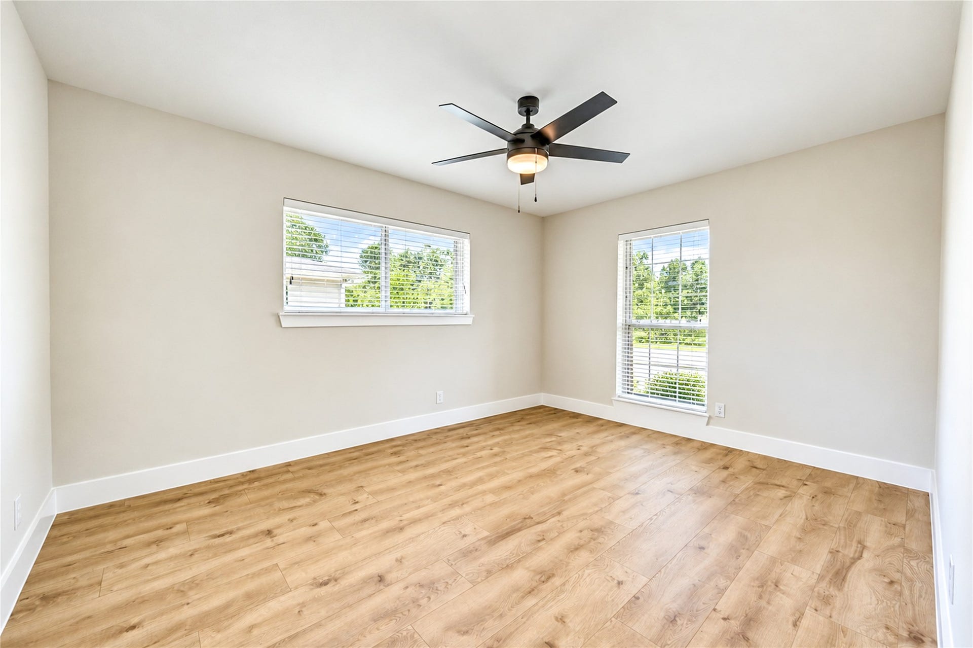 10607 Del Monte Drive, Houston, TX 77042 Spacious secondary bedroom showcases beautiful new engineered wood flooring, a new ceiling fan, large windows, and updated Shaker-style baseboards and door casings.