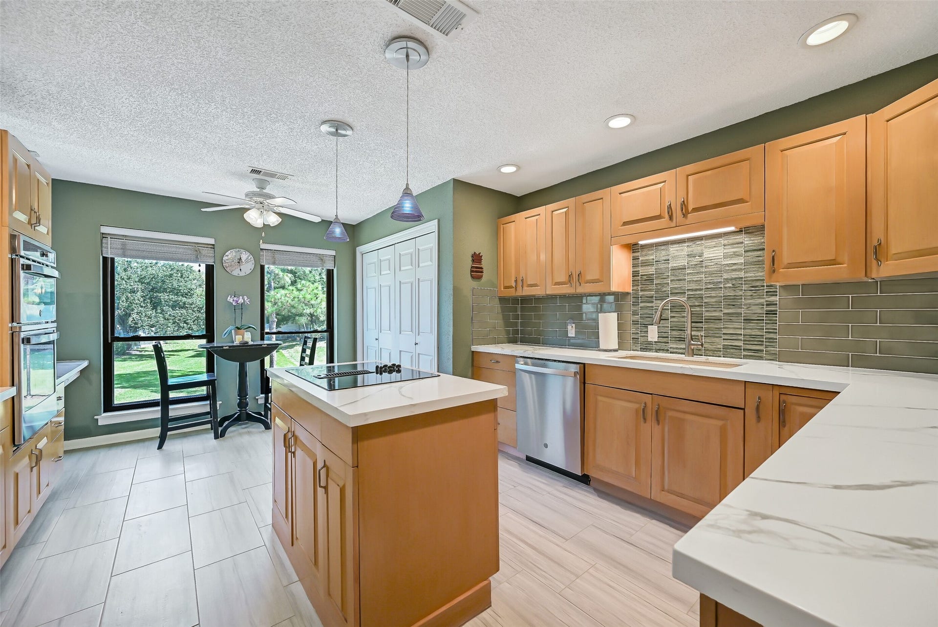 18214 Bal Harbour Drive, Nassau Bay, TX 77058 This home also offers a beautifully remodeled second-floor kitchen that combines quartz countertops, blonde oak cabinetry & a distinctive seafoam-green subway and glass tile backsplash. A center island with GE Profile downdraft cooktop, 2024 stainless GE appliances & sunny breakfast area overlooking the park-like greenspace complete this inviting space.
