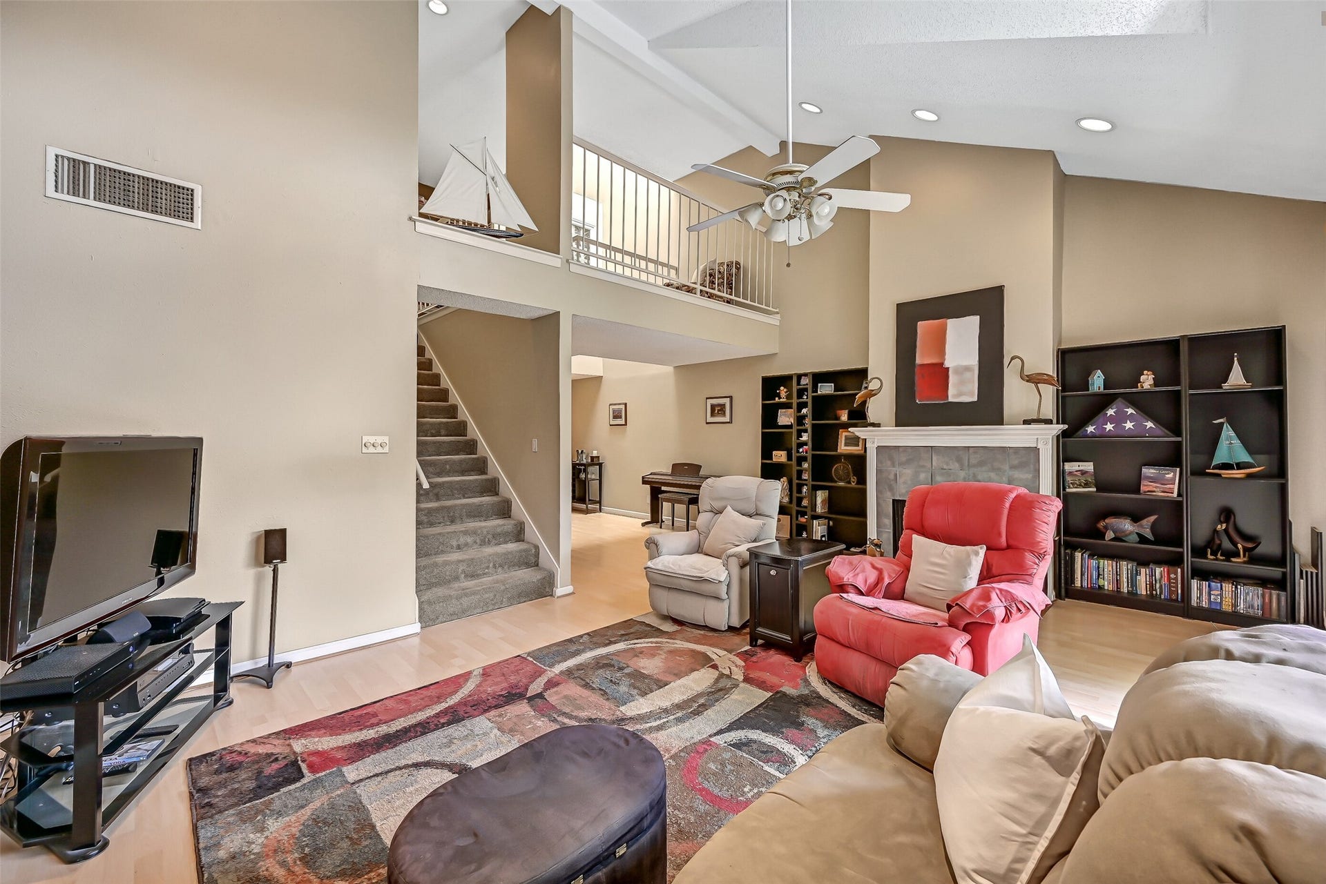 18214 Bal Harbour Drive, Nassau Bay, TX 77058 A first look begins in the spacious second-floor living room with water views and balcony access makes an impression with its soaring two-story ceiling, recessed lighting, laminate flooring & wood-burning fireplace with gray tile surround and crisp white mantel. An open loft overlooks the room from the third floor, adding to the sense of space.