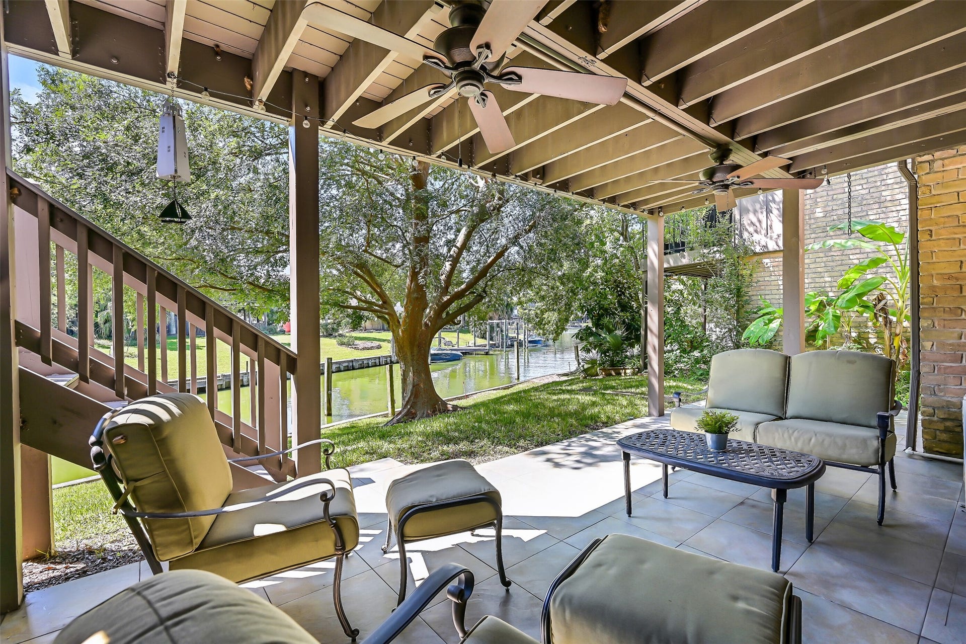 18214 Bal Harbour Drive, Nassau Bay, TX 77058 What a relaxing spot to end the day while you enjoy a Gulf breeze on your private patio! This 22' x 12' covered patio features tile flooring, exposed overhead beams & two ceiling fans, with room for outdoor seating and dining. The mature Chinese Elm provides welcome shade, while the canal and nearby lagoon offer ever-changing views of passing boats and native birds.