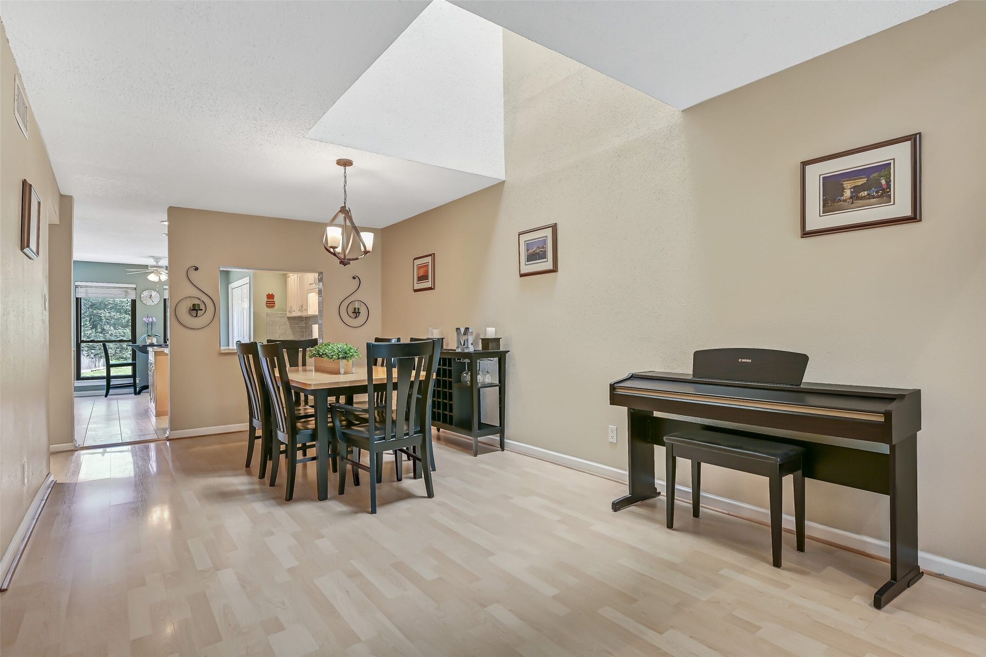 18214 Bal Harbour Drive, Nassau Bay, TX 77058 Just up the staircase to the second floor is your formal dining area, featuring natural light from the skylight above, a decorative chandelier, wood-look laminate flooring, & plenty of space for a full dining set. A convenient pass-through serving bar connects directly to the kitchen, while the open layout allows natural light to travel between the dining and living areas.