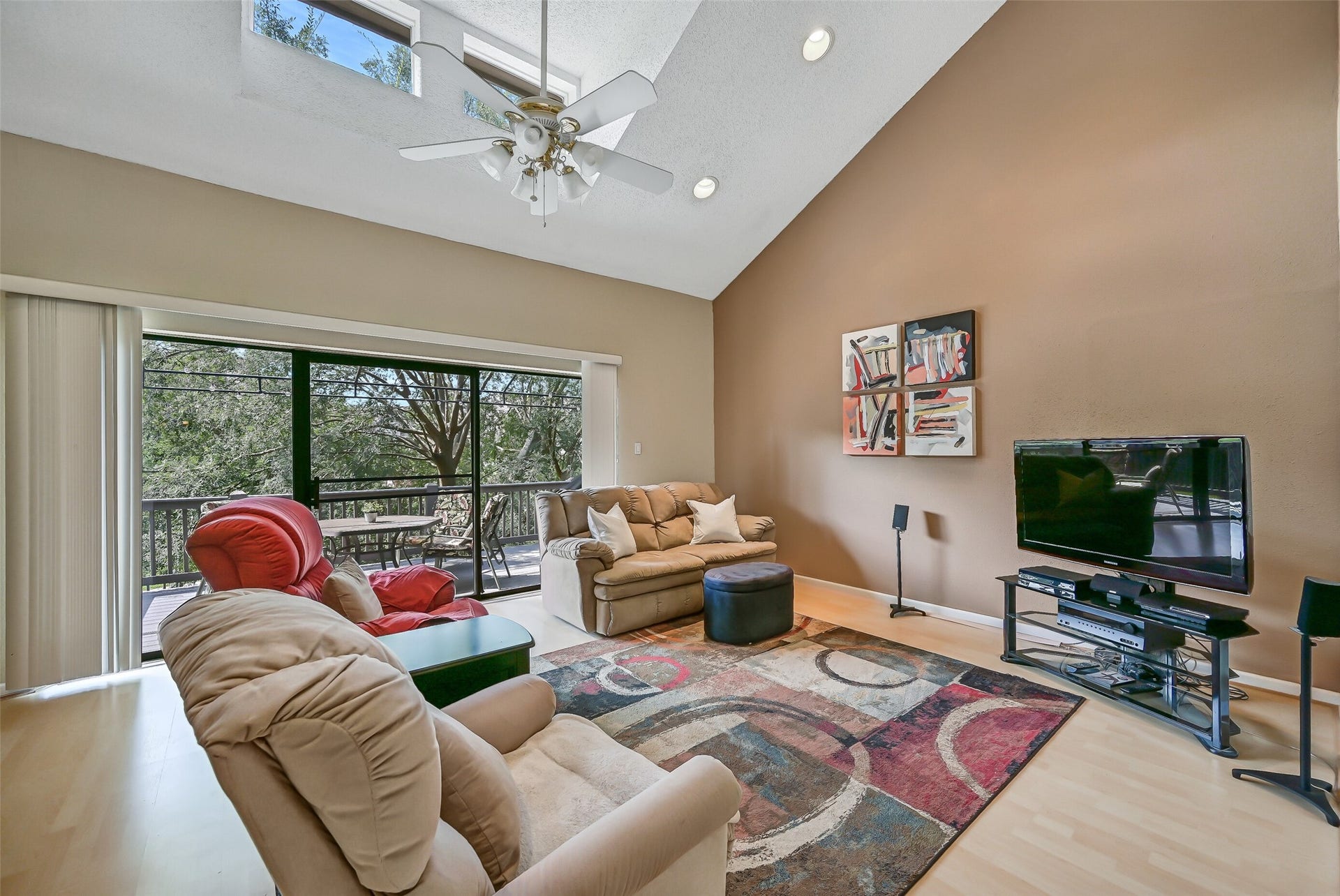 18214 Bal Harbour Drive, Nassau Bay, TX 77058 A wall of windows and sliding glass doors fills the living room with natural light, while transom windows above bring even more sunshine into the space. Step outside to the extended 21' x 11' composite Trex-decked balcony, where mature trees frame the canal and beautiful sunset views.