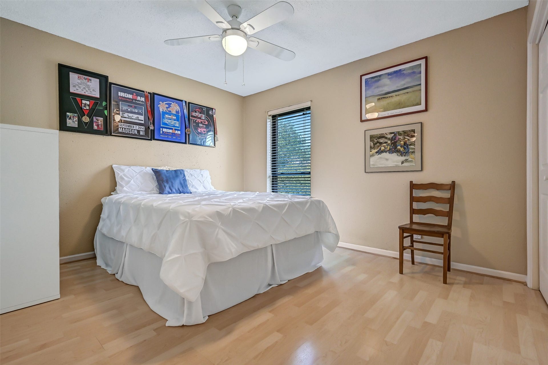 18214 Bal Harbour Drive, Nassau Bay, TX 77058 Another secondary bedroom is also located on the main living level, offering laminate flooring, neutral walls, a ceiling fan & bifold closet. A window overlooks the mature trees and park-like greenspace across the street, providing a pleasant, private view with no townhomes directly in front.