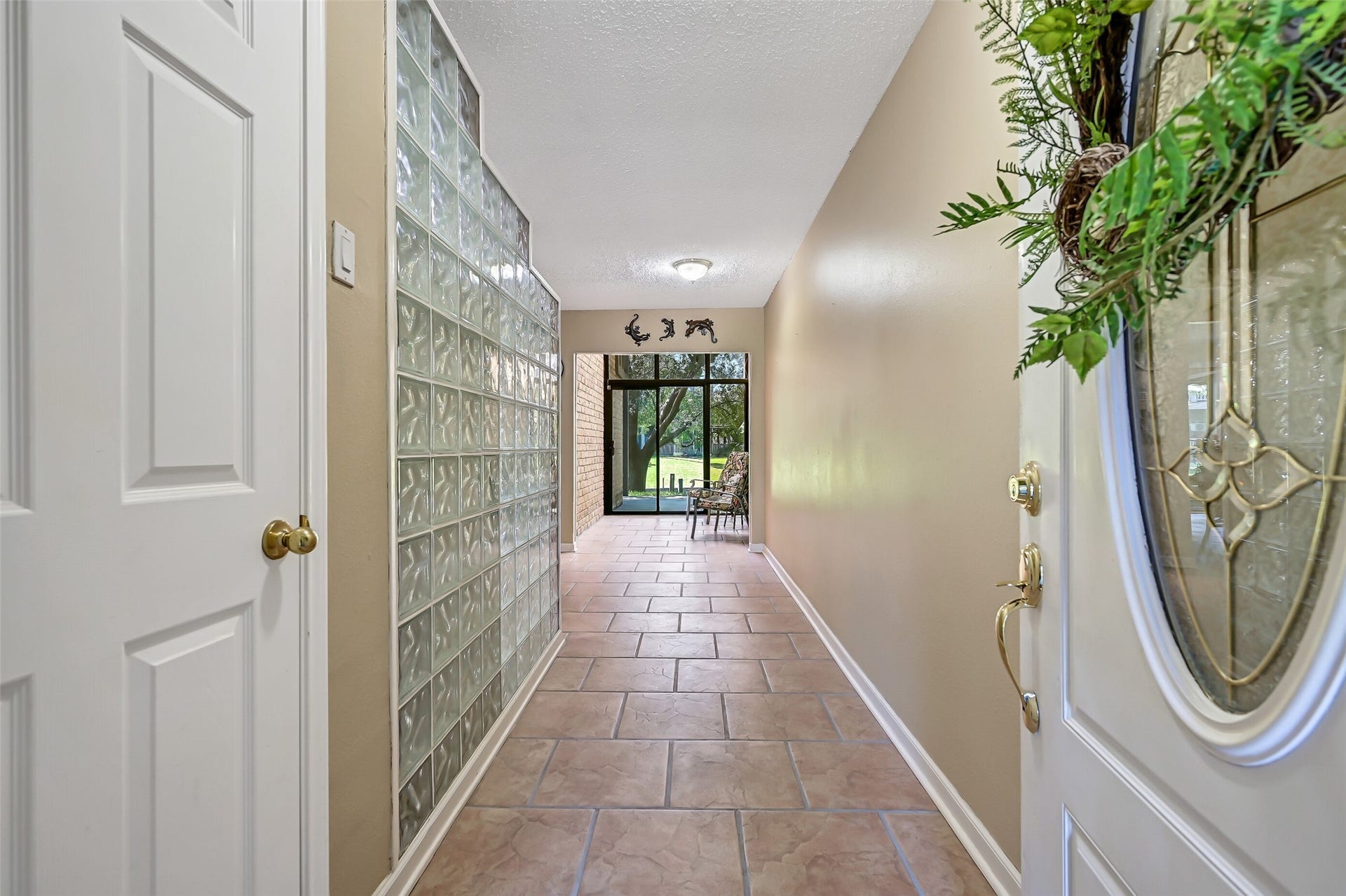 18214 Bal Harbour Drive, Nassau Bay, TX 77058 Back on the ground floor, let's tour the gameroom/guest quarters and flex spaces. The foyer welcomes you with durable tile flooring, a large coat closet & a distinctive glass-block wall separating the entry from the guest kitchen. Straight ahead, the two-story sunroom draws your eye toward the mature elm and canal beyond, offering an inviting first glimpse of the waterfront setting.