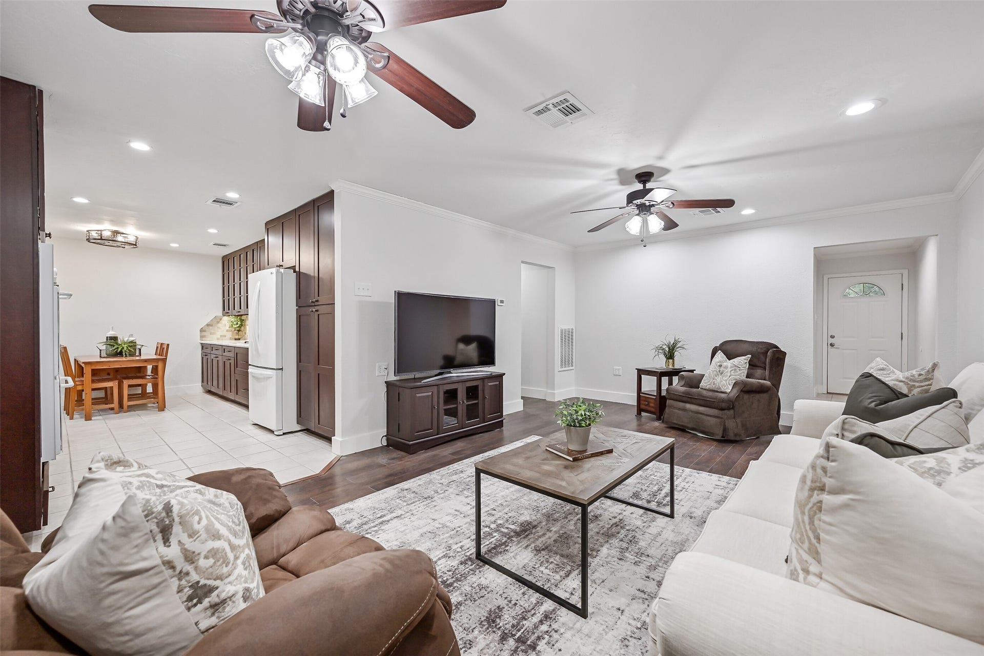 5403 Carmona Lane, Pearland, TX 77584 Looking back toward the front entry, this angle shows the family room's generous scale and easy connection to the kitchen & breakfast area. Luxury vinyl plank flooring runs throughout the space, while recessed lighting & two ceiling fans provide plenty of illumination.
