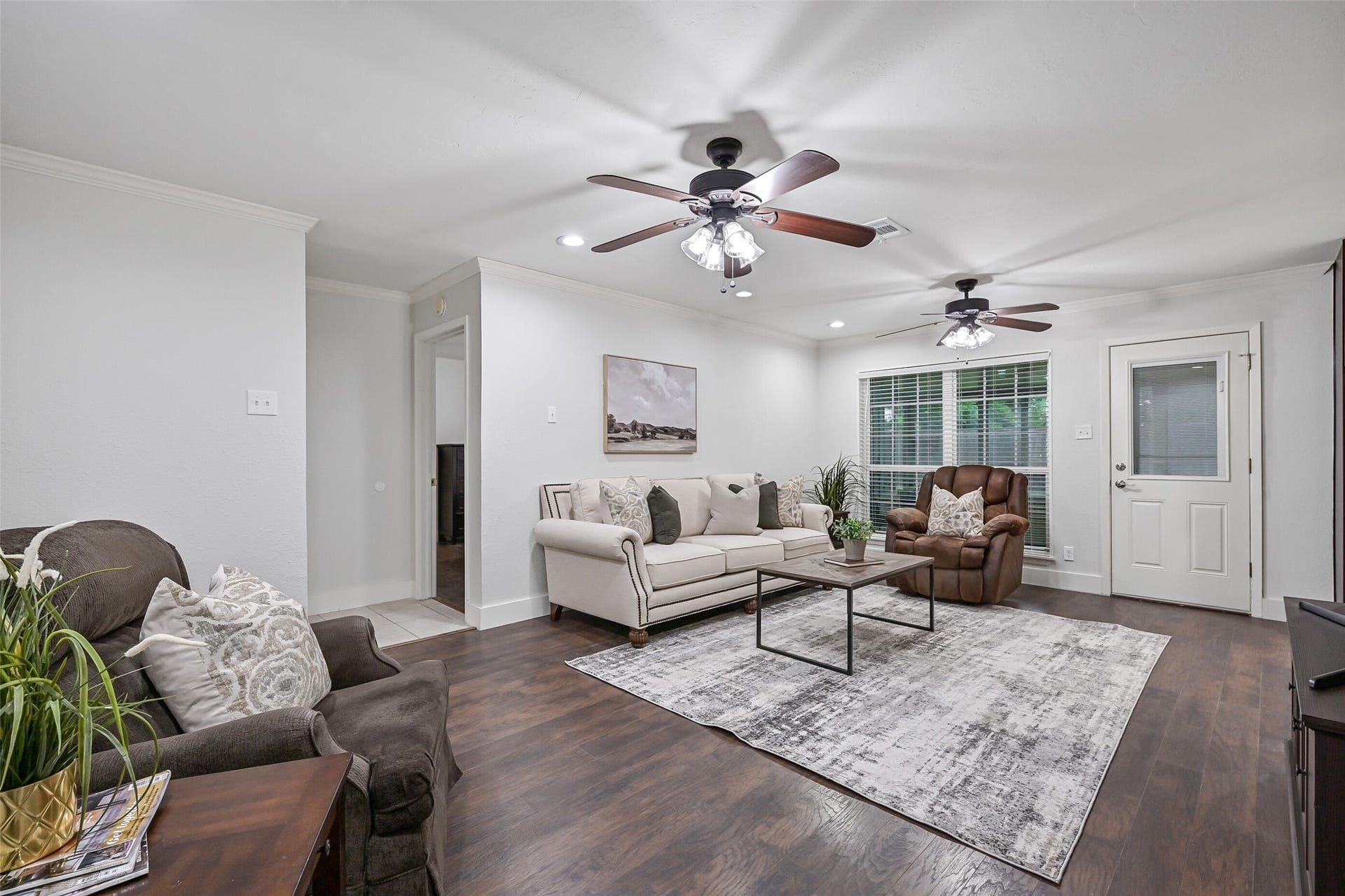 5403 Carmona Lane, Pearland, TX 77584 A large rear-facing window fills the family room with natural light and overlooks the screened porch beyond. At 21' x 14', the room offers abundant space for gathering, with luxury vinyl plank flooring, crown molding, recessed lighting & dual lighted ceiling fans.
