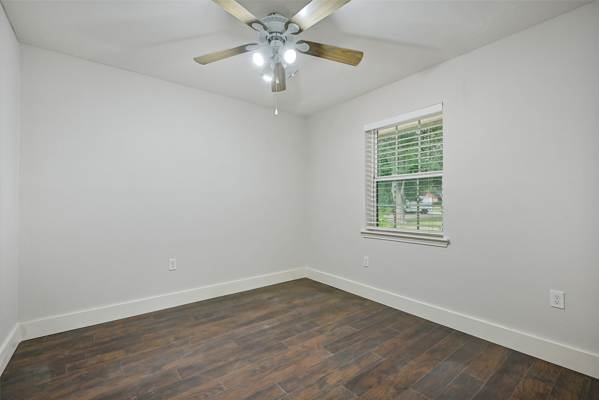 5403 Carmona Lane, Pearland, TX 77584 The fourth bedroom continues the home's fresh neutral finishes with luxury vinyl plank flooring, oversized baseboards & a lighted ceiling fan. A front-facing window brings in natural light, while a bifold-door closet provides dedicated storage.
