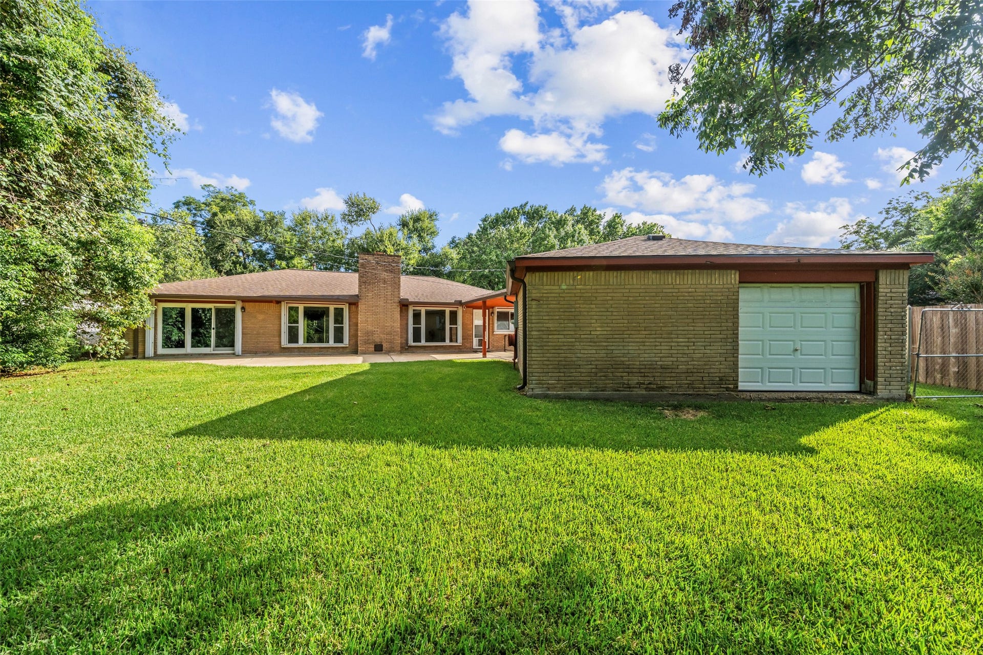 7714 Pecanwood Street, Hitchcock, TX 77563 The detached 2 car garage on the right has a door that leads directly out towards the bayou. Inside the garage is a storage area that allows you to slide your kayak out the garage door and down to your private boat pier! Additional attic space in garage for plenty of storage and a workspace with a workbench and storage.