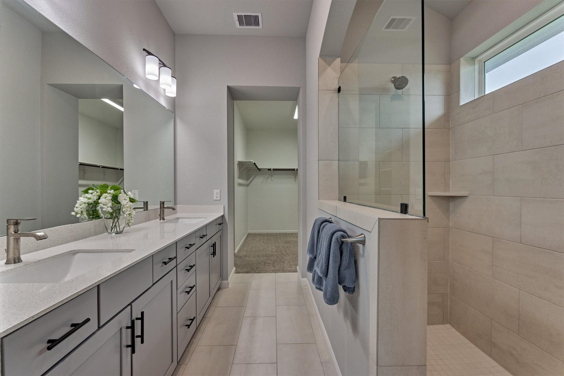 Exceptional in design, this bathroom offers impressive storage opportunities, eye-catching walk-in shower, and dual sink space to simplify daily prep.