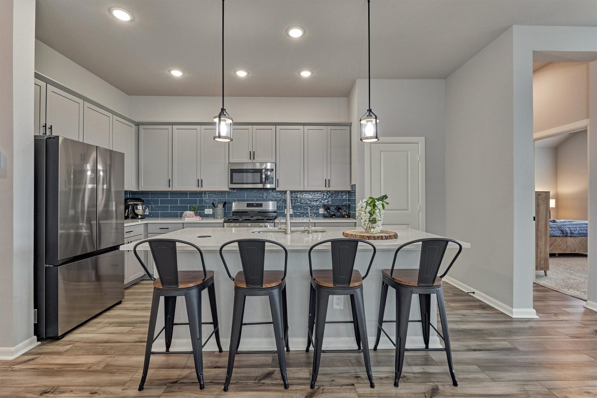 Designer backsplash pops next to the quartz counters and stainless appliance package. Don't miss the walk in pantry for added storage options!