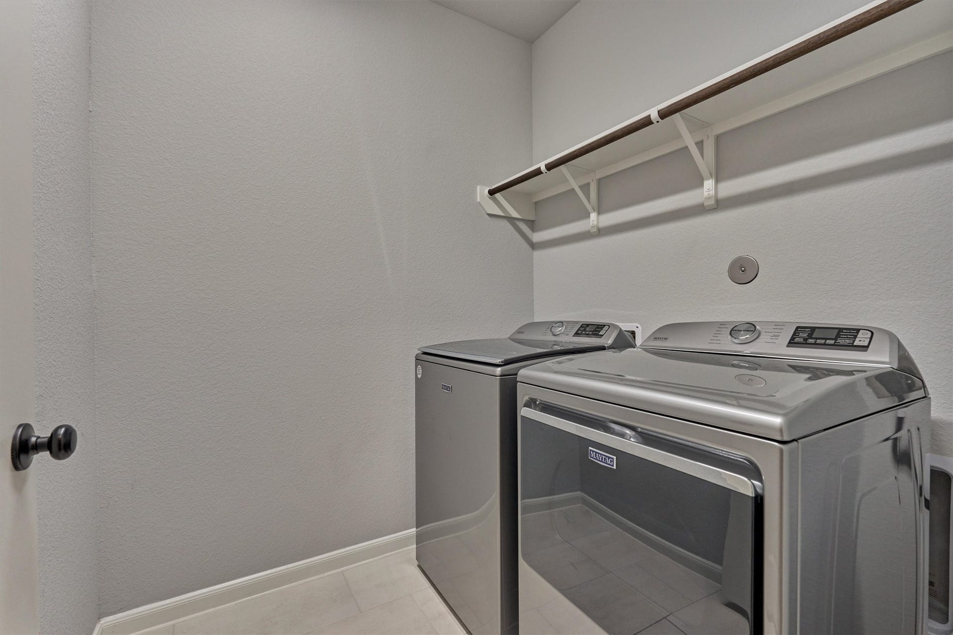 Large utility room with shelf for additional storage + hanging space.
