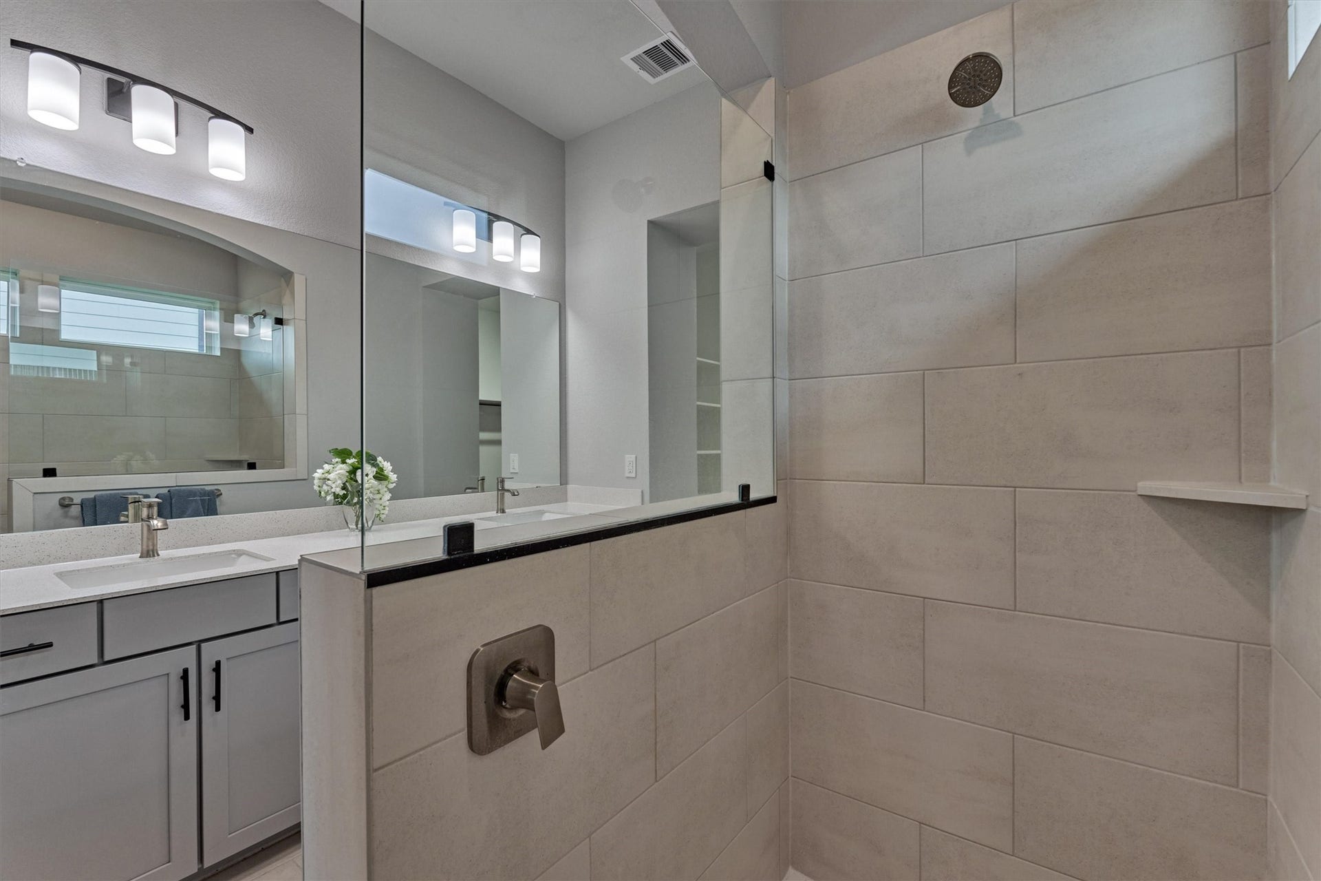 Chic tile selection is the perfect fit for this oversized shower. Windows allow additional natural light to flow through this space.