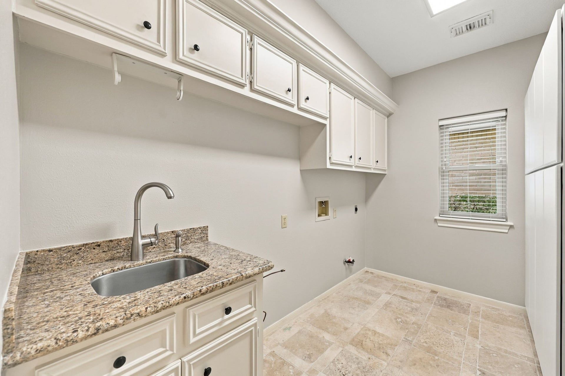 4711 Westerdale Drive, Fulshear, TX 77441 The spacious Laundry Room is thoughtfully designed with a built-in sink, granite countertop, and brushed nickel gooseneck faucet. Abundant built-in shelving provides plenty of storage and organization, making everyday tasks a little easier.
