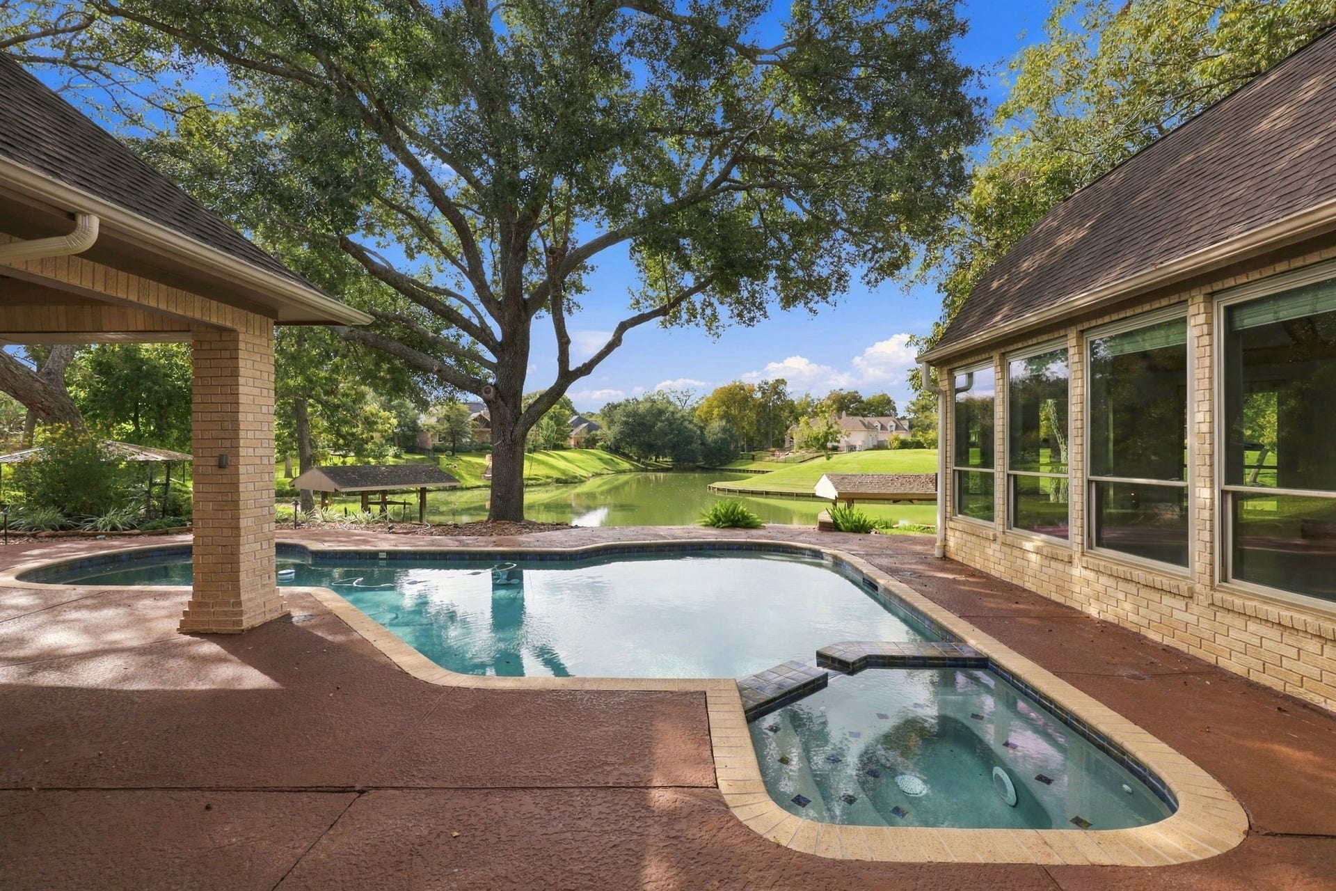 4711 Westerdale Drive, Fulshear, TX 77441 You simply can't get enough of this view! With the sparkling waters of Pecan Lake, beautiful, mature trees, and the inviting pool and spa, every glance reminds you just how special this setting truly is.
